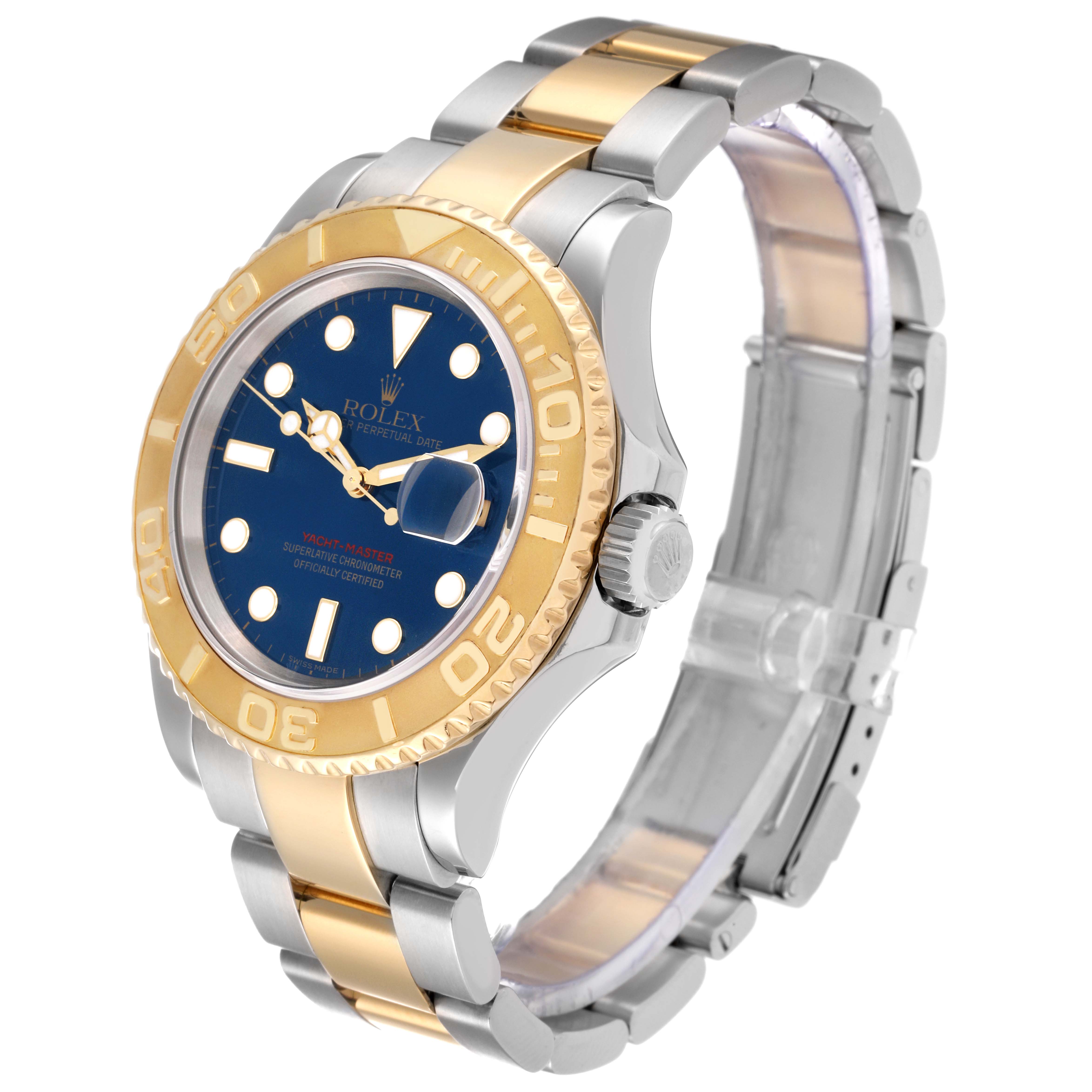 The Rolex Yacht-Master 16623 Men
s Steel and Gold (two tone) Blue Dial 16623 Men
s Steel and Gold (two tone) Blue Dial watch is shown from a front-left angle, highlighting its gold bezel, blue dial, and bi-metal bracelet.