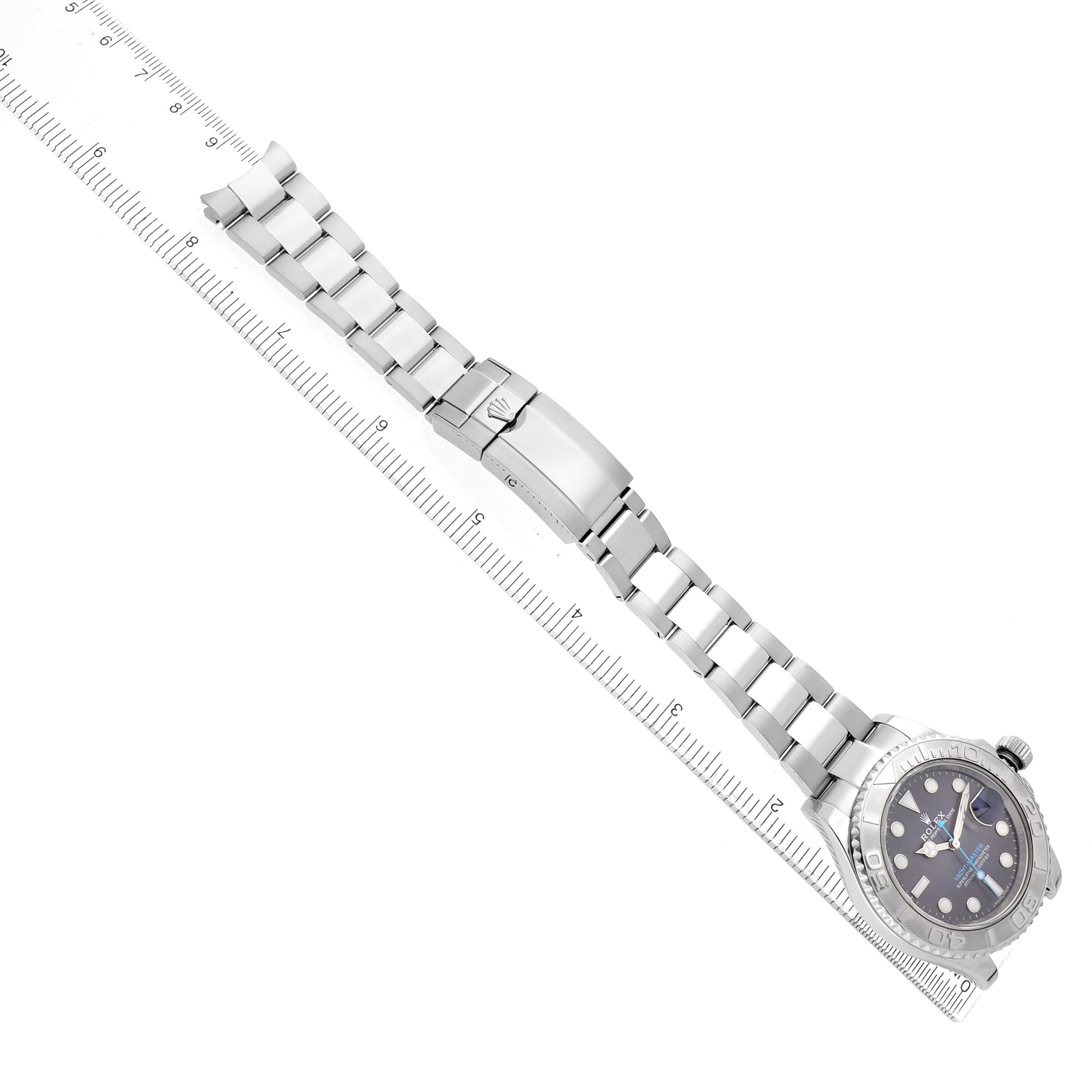 The Rolex Yacht-Master 116622 Men's Stainless Steel Grey Dial watch is shown from a top view, featuring the face, bezel, bracelet, and clasp alongside a ruler.