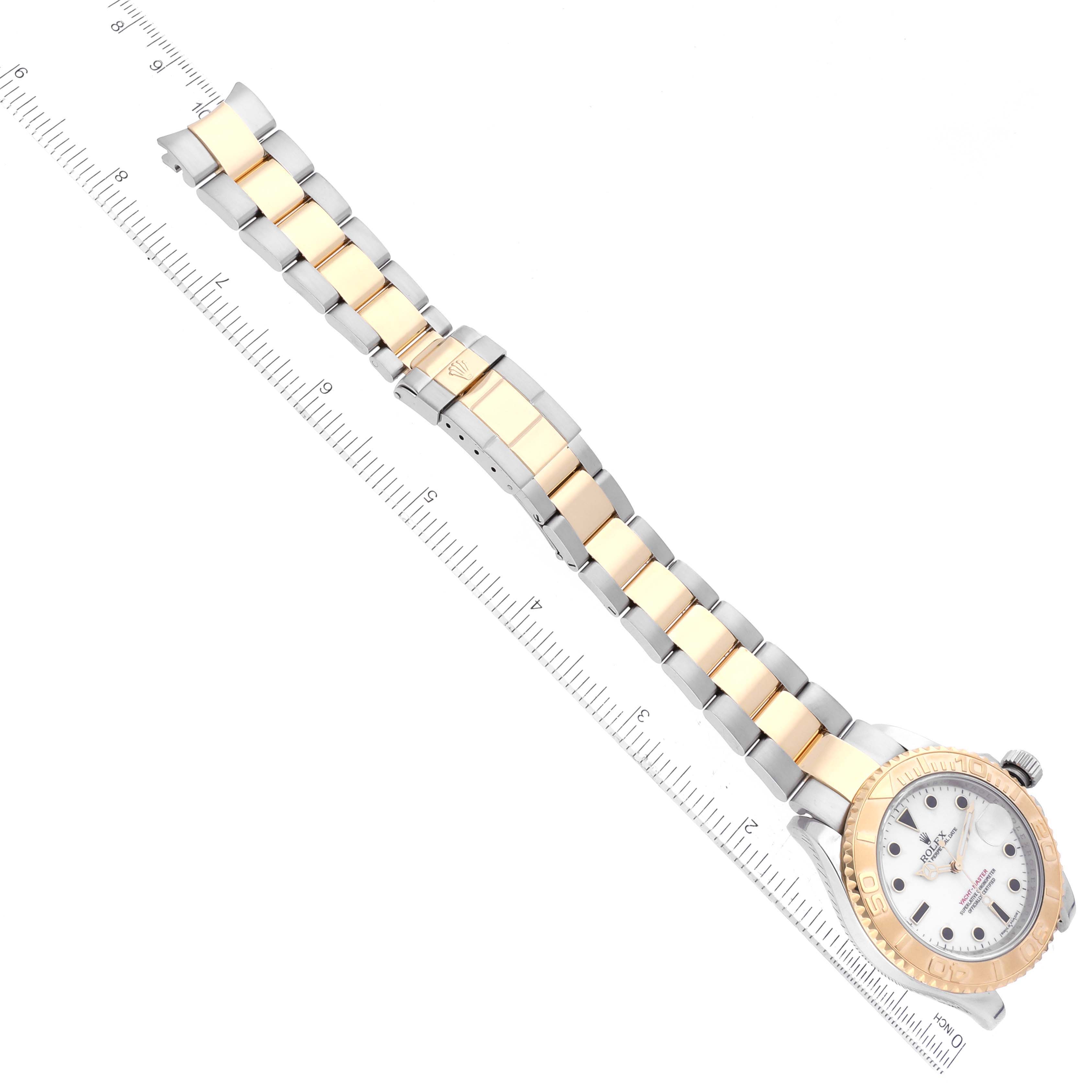 The image shows a top-down view of the Rolex Yacht-Master 16623 Men's Steel and Gold (two tone) White Dial 16623 Men's Steel and Gold (two tone) White Dial watch, highlighting its bezel, dial, and bracelet alongside a measuring ruler.