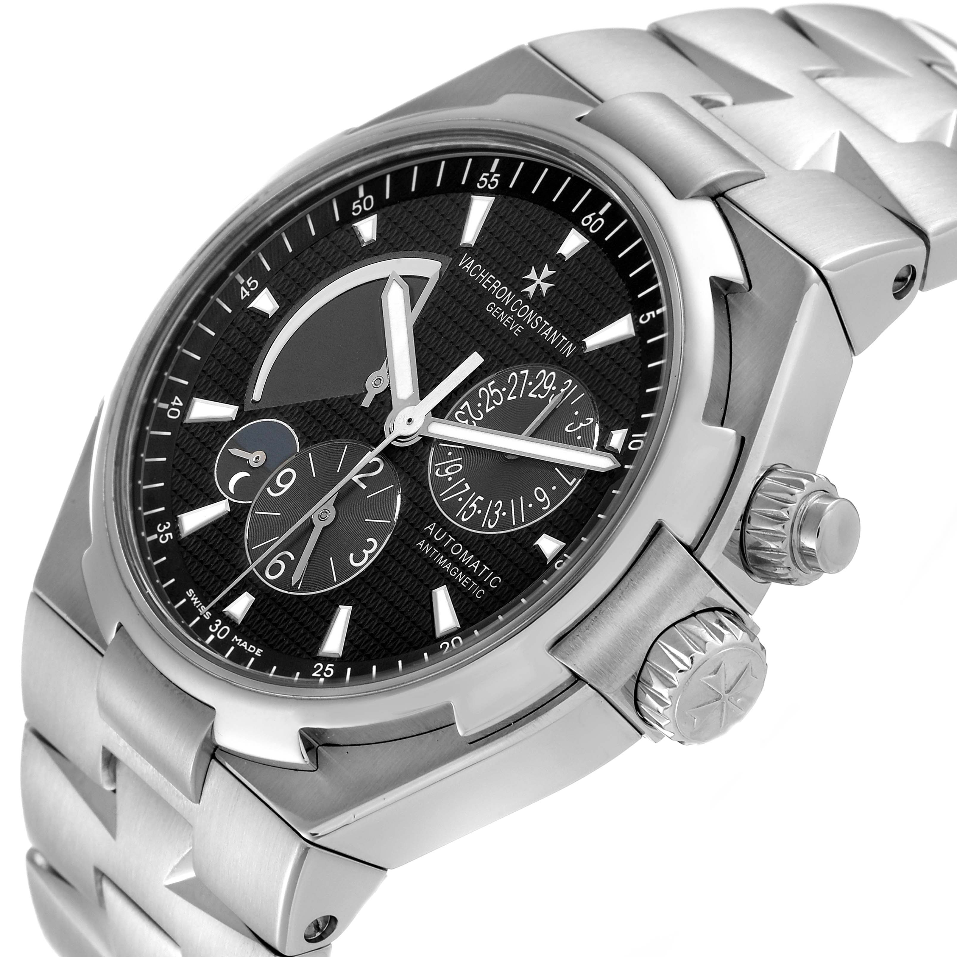 The image shows a close-up, angled view of the Vacheron Constantin Overseas 47450/B01A-9227 Men
s Stainless Steel Black Dial 47450/B01A-9227 Men
s Stainless Steel Black Dial watch, highlighting its dial, crown, and part of the bracelet.