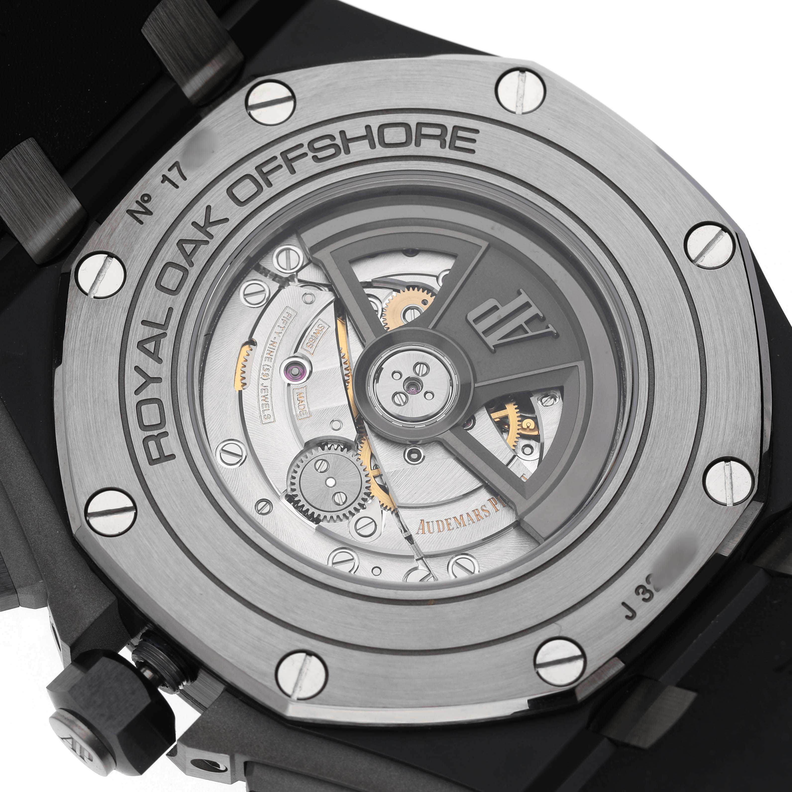The image shows the back of an Audemars Piguet Royal Oak Offshore 26405CE Men's Ceramic Grey Dial watch, highlighting its mechanical movement.