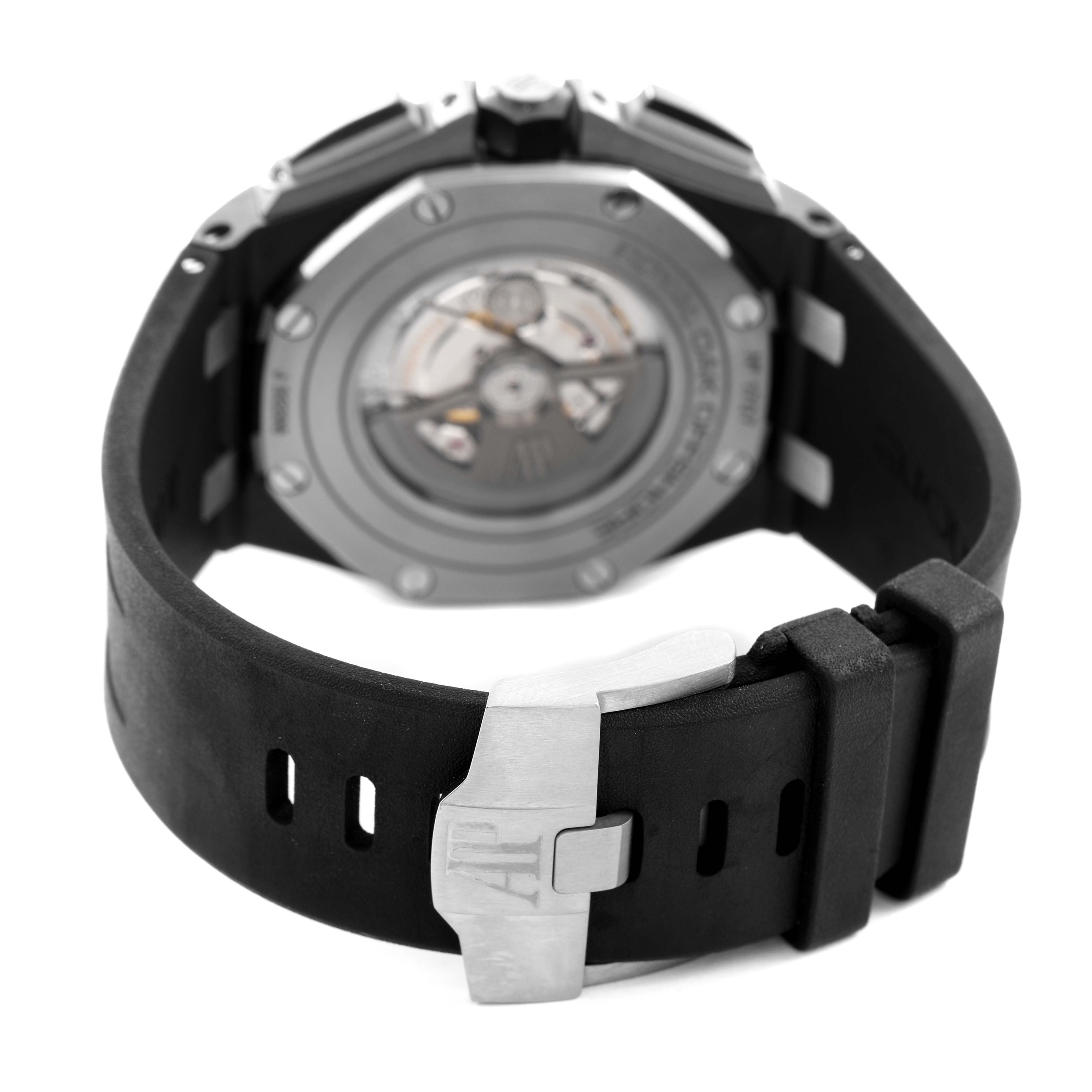 The image shows the back view of the Audemars Piguet Royal Oak Offshore 26405CE Men's Ceramic Grey Dial, highlighting its open caseback and rubber strap with a clasp.