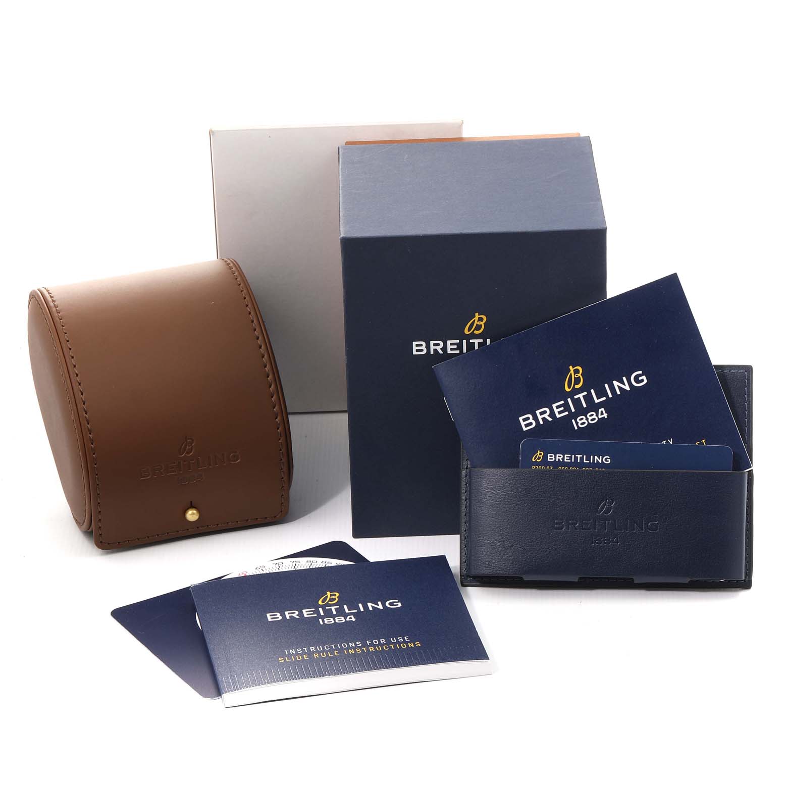 The image shows Breitling Navitimer AB0121 Men's Stainless Steel Black Dial AB0121 Men's Stainless Steel Black Dial accessories including a brown watch case, blue instruction booklets, and a blue cardholder.