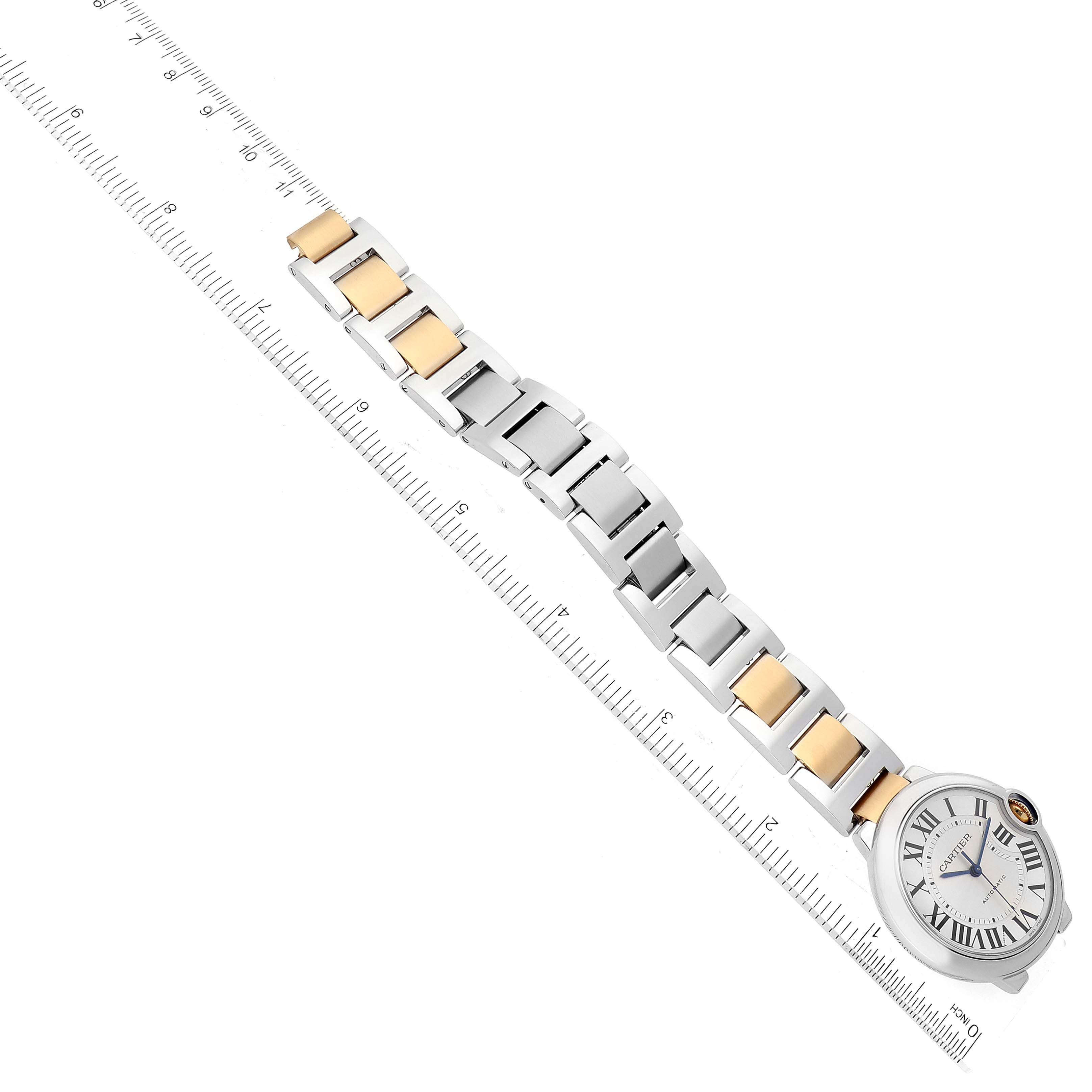 The image shows a Cartier Ballon Bleu W2BB0012 Women
s Steel and Gold (two tone) Silver Dial W2BB0012 Women
s Steel and Gold (two tone) Silver Dial watch laid flat with the face and full bracelet visible alongside a ruler for scale.