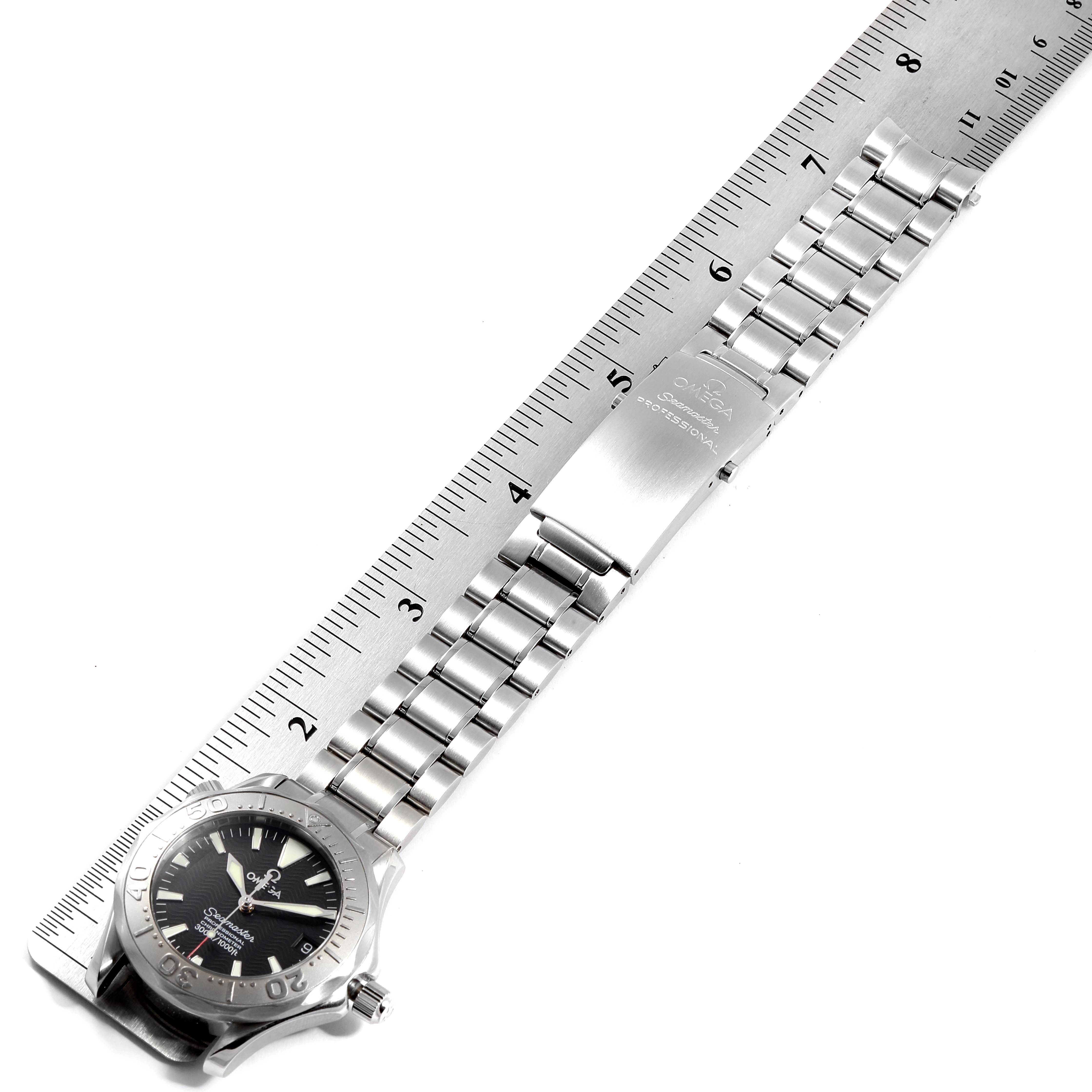 The image shows an Omega Seamaster 2236.50.00 Men
s Stainless Steel Black Dial 2236.50.00 Men
s Stainless Steel Black Dial watch from a top view, including the watch face, bezel, crown, and stainless steel bracelet alongside a ruler.