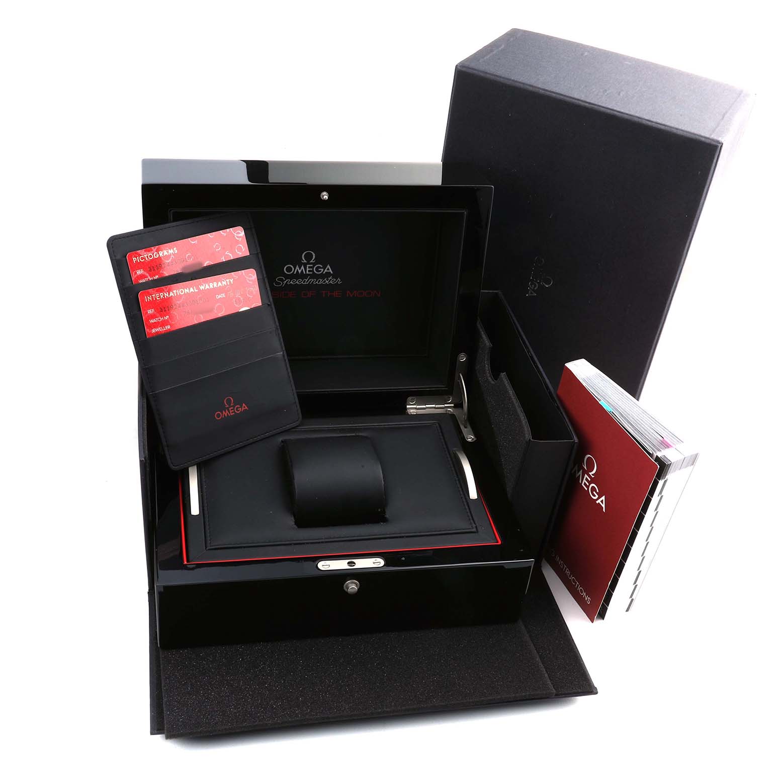 The image shows an Omega Speedmaster 311.92.44.30.01.001 Men's Ceramic Black Dial watch box, open, displaying warranty cards and a manual beside it.
