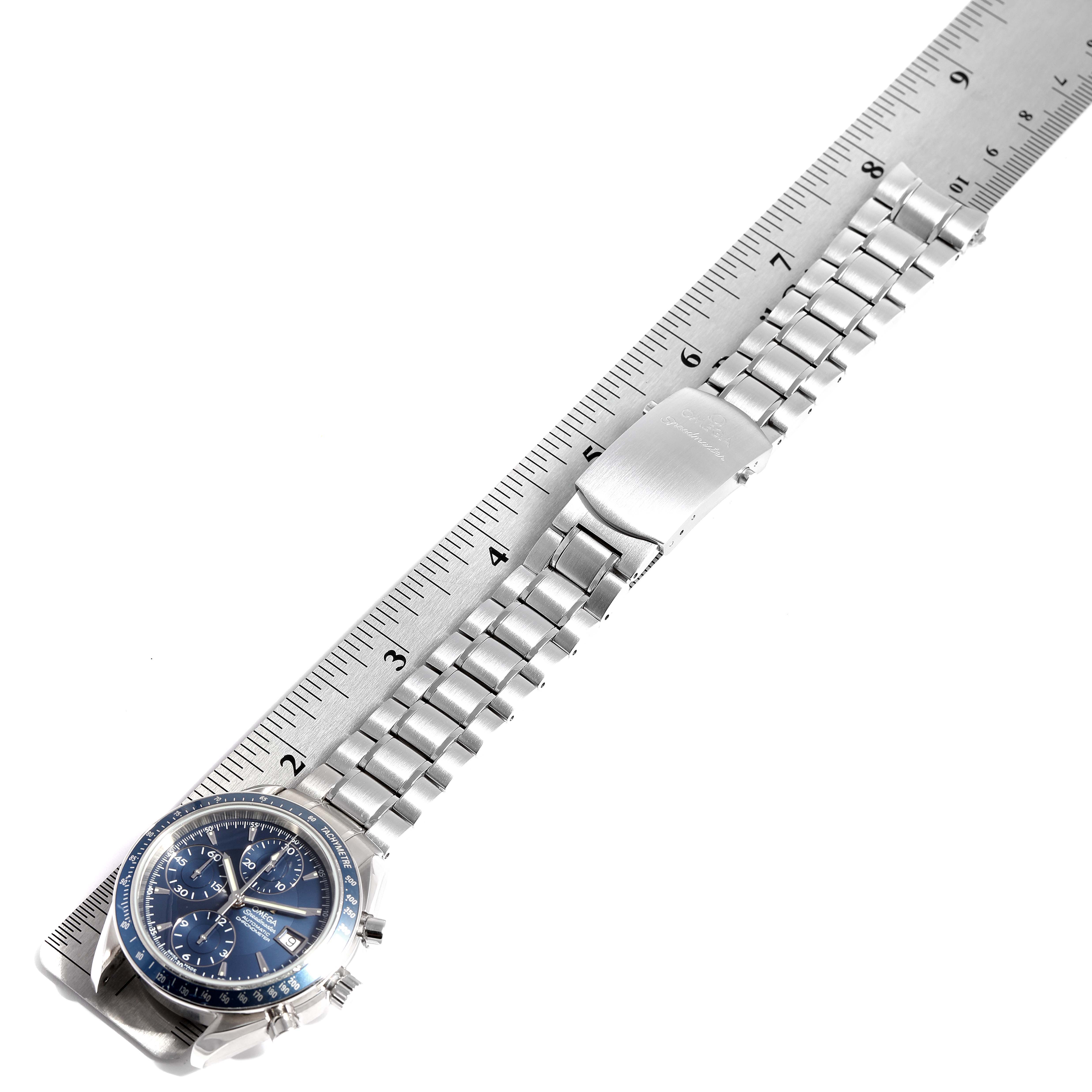The Omega Speedmaster 3212.80.00 Men's Stainless Steel Blue Dial 3212.80.00 Men's Stainless Steel Blue Dial watch is shown from a top-down angle with its stainless steel bracelet extended alongside a ruler.