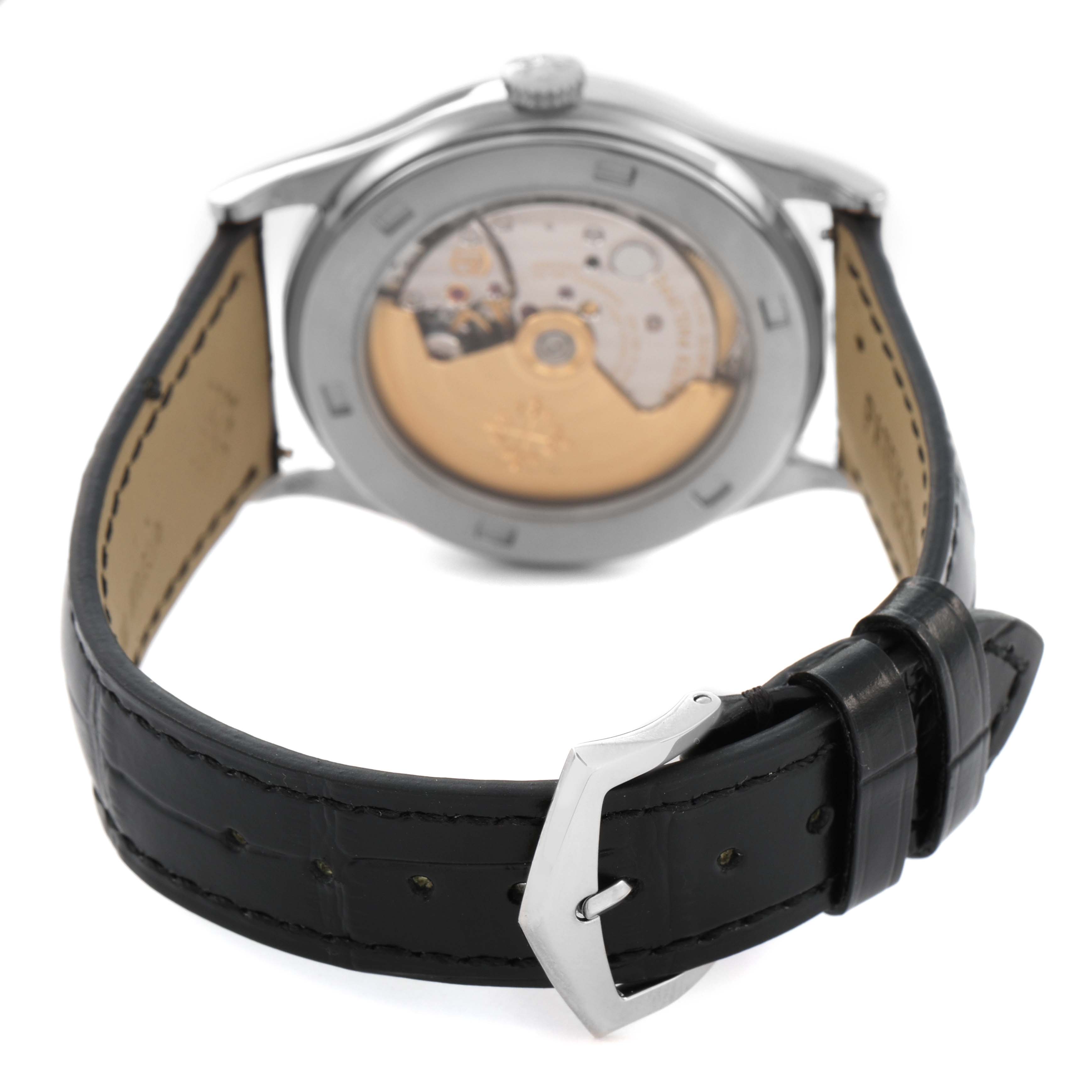 The image shows the back of a Patek Philippe Calatrava 5296G Men's White Gold Silver Dial watch, highlighting its movement through a transparent case back and leather strap.