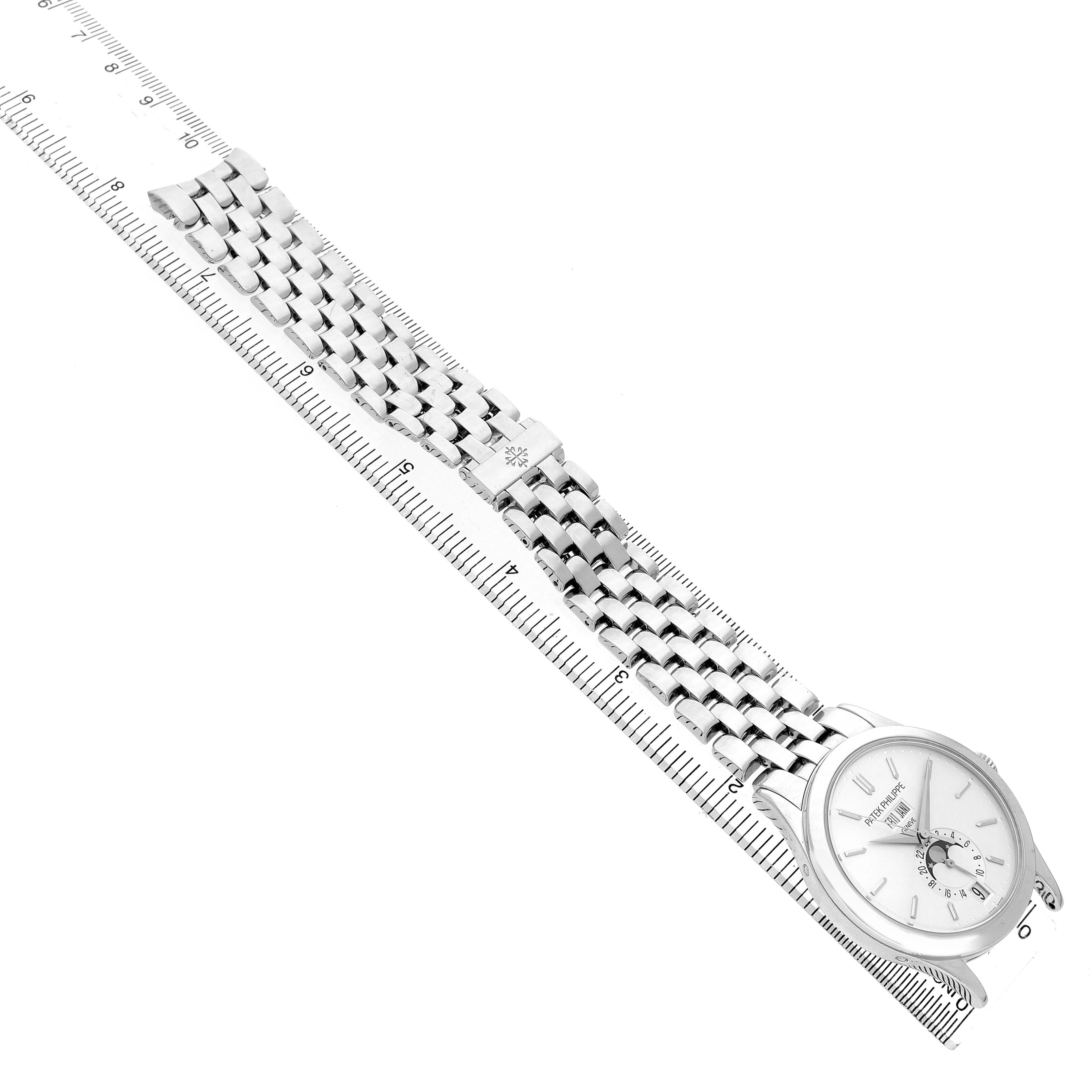The Patek Philippe Complications 5396G Men's White Gold Silver Dial watch is angled to show the full face and metal bracelet, with a ruler for scale.