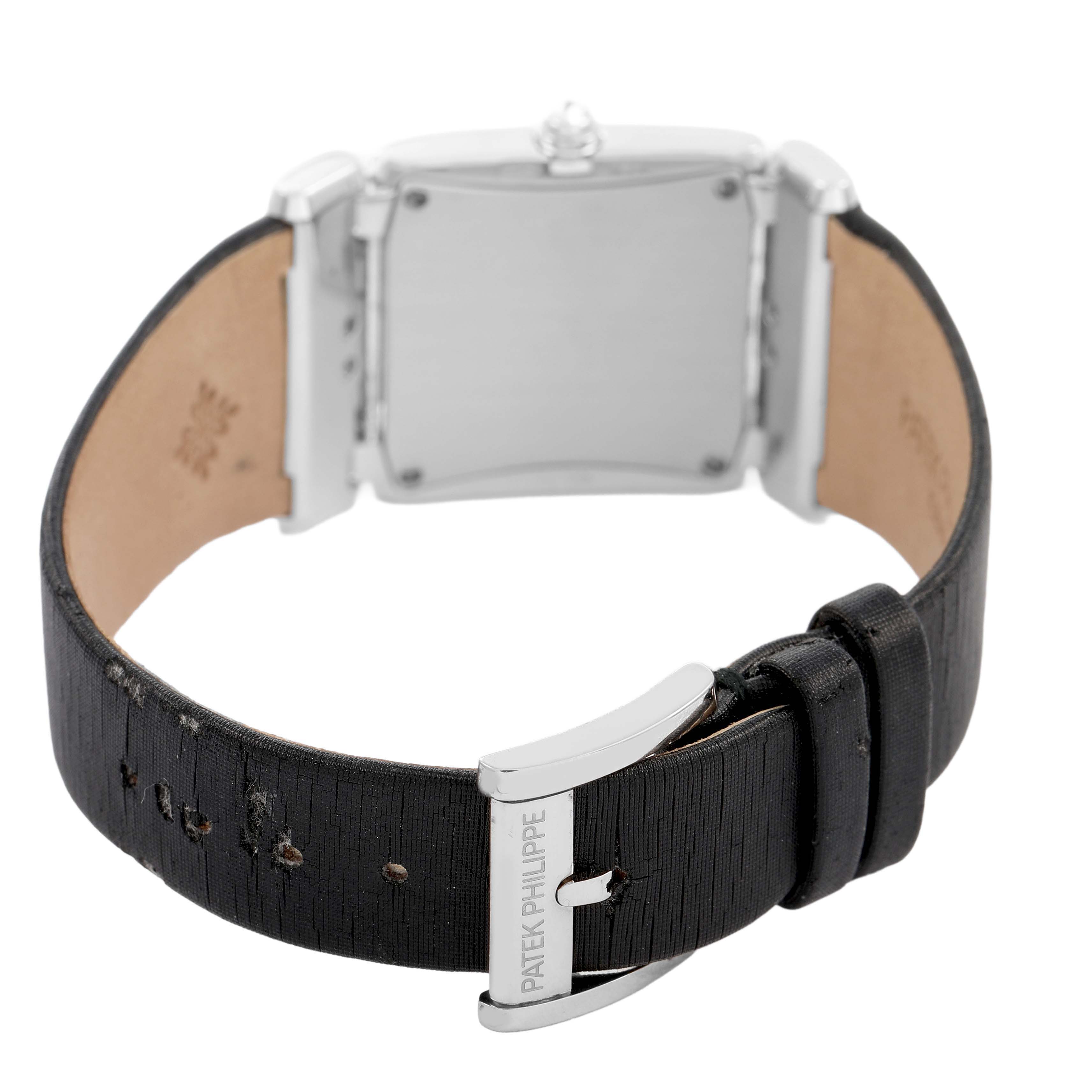 The image shows the back view of a Patek Philippe Twenty-4 4920G Women's White Gold Silver Dial model, highlighting the case back and black leather strap with a buckle clasp.