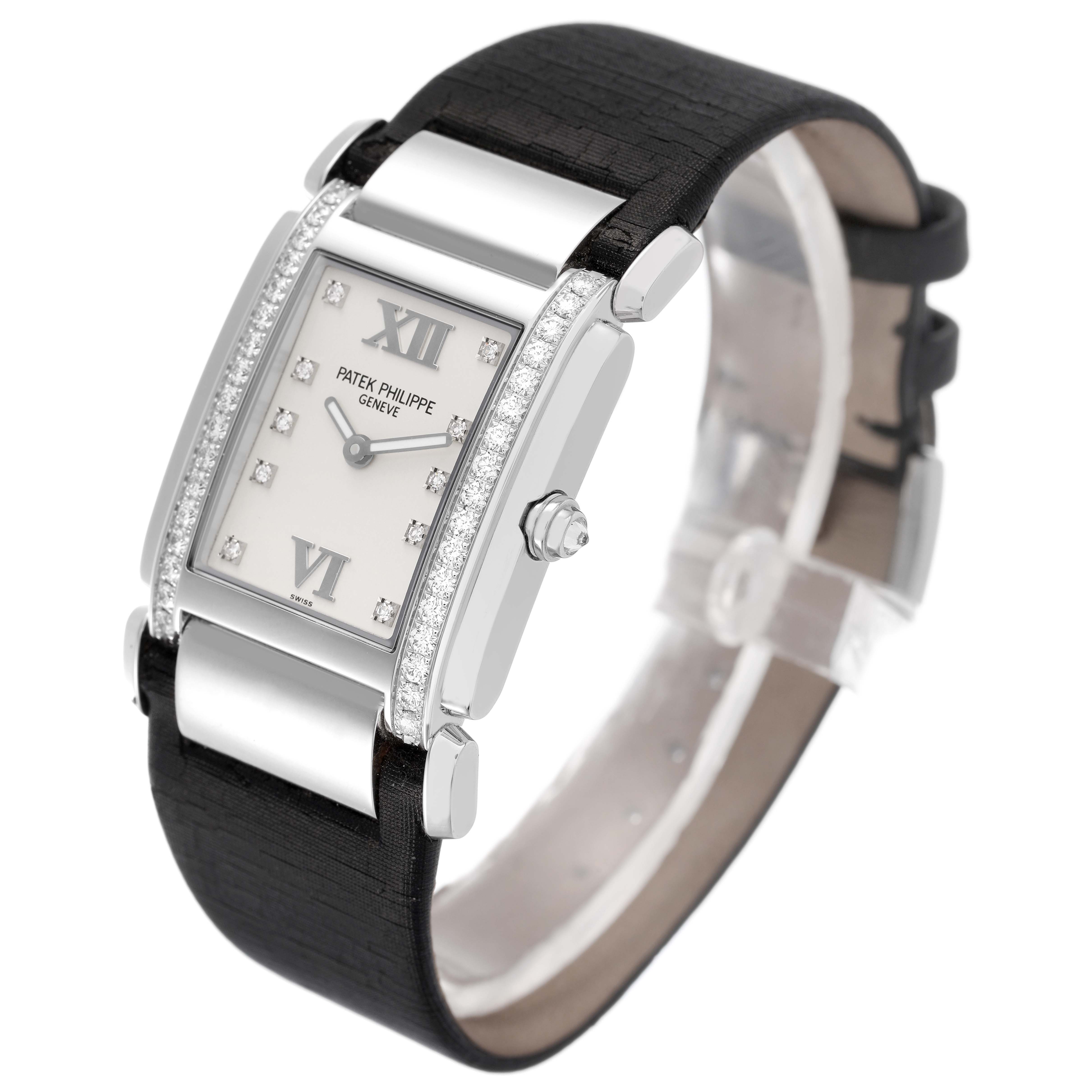 The Patek Philippe Twenty-4 4920G Women's White Gold Silver Dial watch is shown at an angled view, displaying the dial, diamond-set case, crown, and strap.