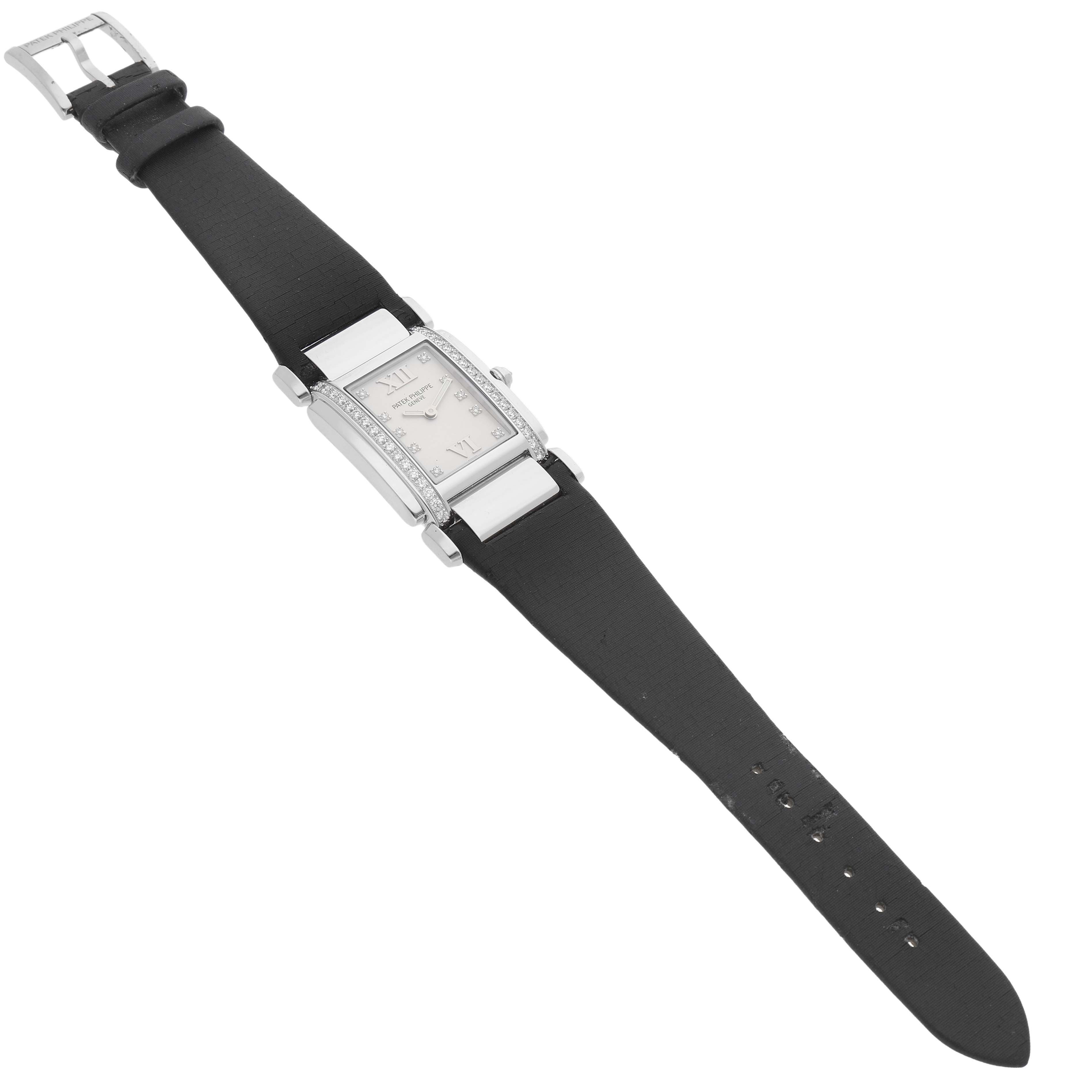 The Patek Philippe Twenty-4 4920G Women's White Gold Silver Dial watch is photographed from an angled top view, showing the entire watch, including the face and black strap.
