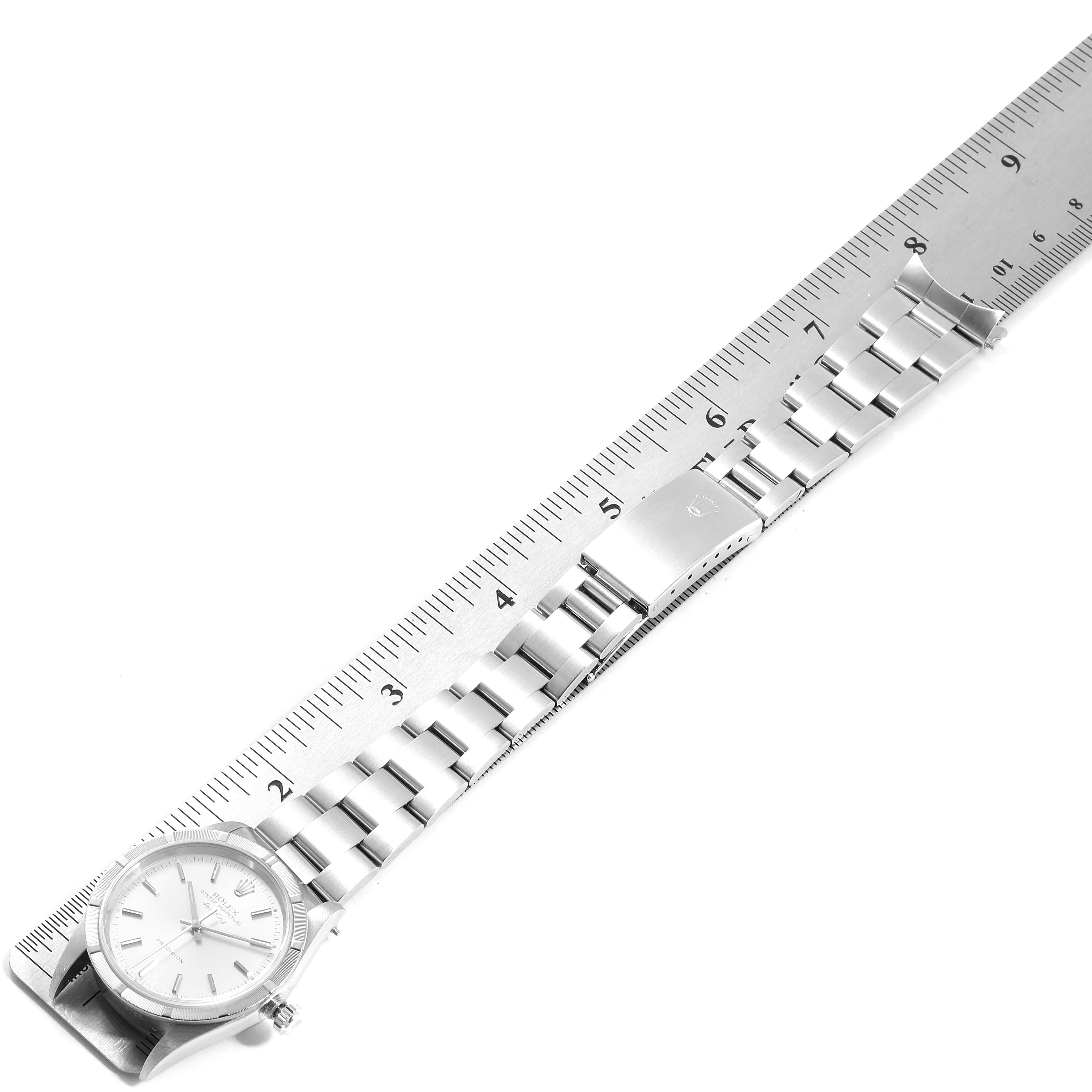 The image shows an overhead view of a Rolex Air-King 14010 Men's Stainless Steel Silver Dial 14010 Men's Stainless Steel Silver Dial watch, including the face, bracelet, and clasp next to a ruler for size reference.