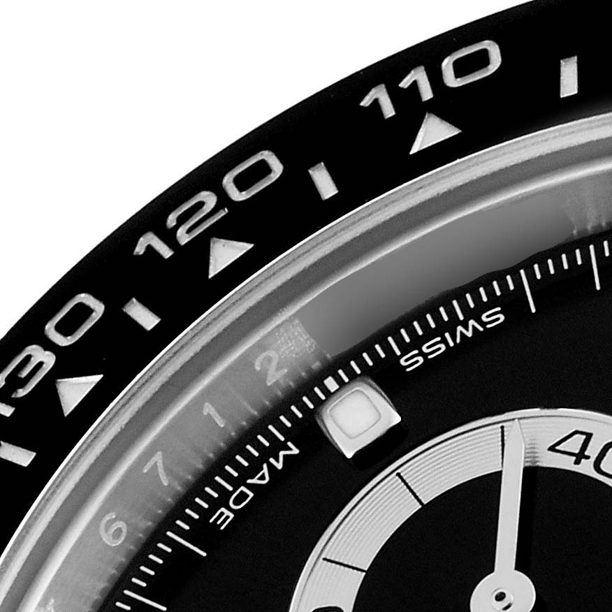 The image shows a close-up of the bezel and part of the dial of a Rolex Daytona 116500 Men's Stainless Steel Black Dial 116500 Men's Stainless Steel Black Dial watch, featuring the tachymeter scale.