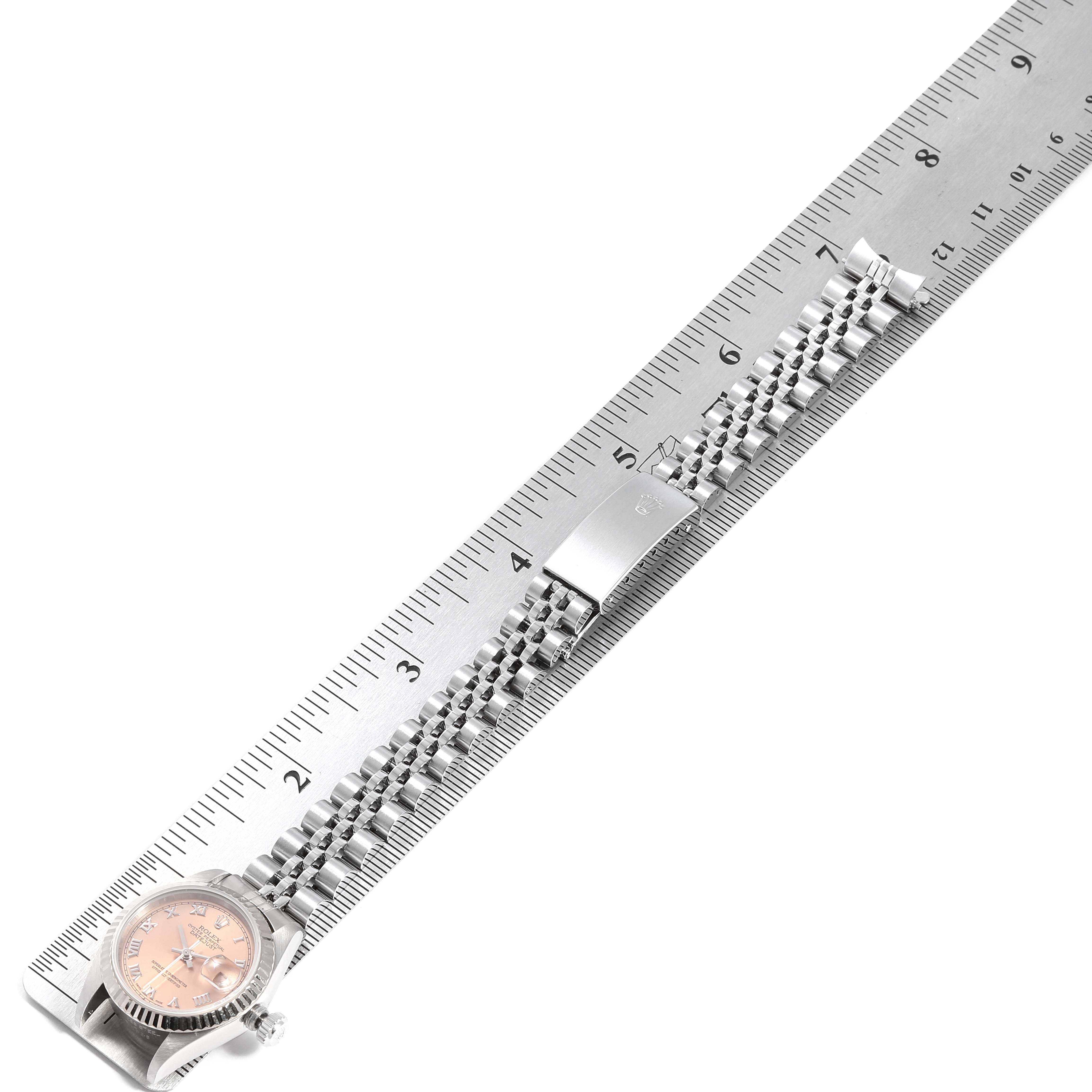 The image shows a Rolex Datejust 69174 Women's Stainless Steel Pink Dial 69174 Women's Stainless Steel Pink Dial watch laid flat against a ruler, displaying its case, dial, bracelet, and clasp.