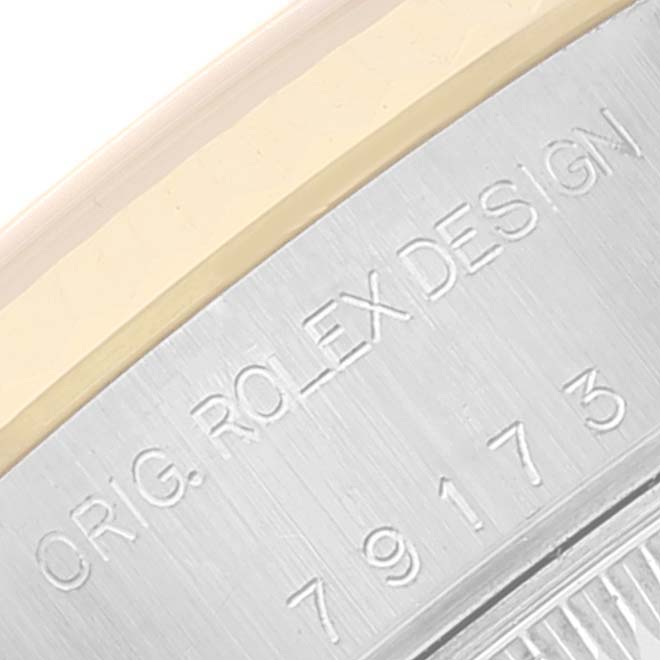 This close-up image shows the engraved serial number and "ORIG. ROLEX DESIGN" marking on the case of a Rolex Datejust 79173 Women's Steel and Gold (two tone) Grey Dial 79173 Women's Steel and Gold (two tone) Grey Dial watch.