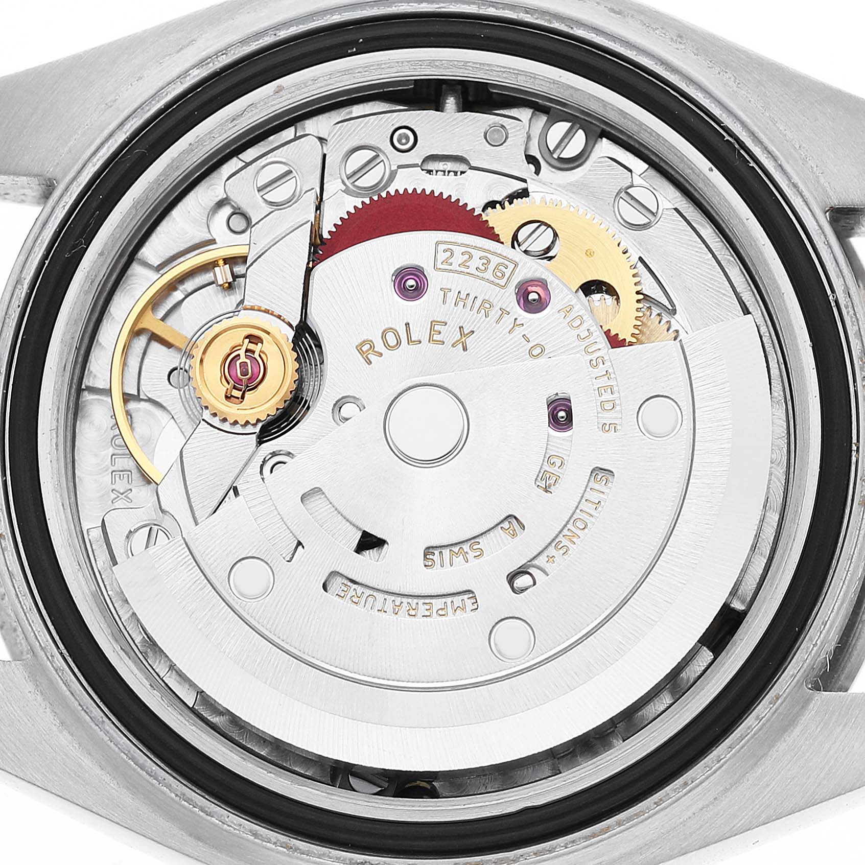 The image shows the intricate movement of a Rolex Datejust 279174 Women's Stainless Steel White Dial watch from a back angle, highlighting gears and inscriptions.