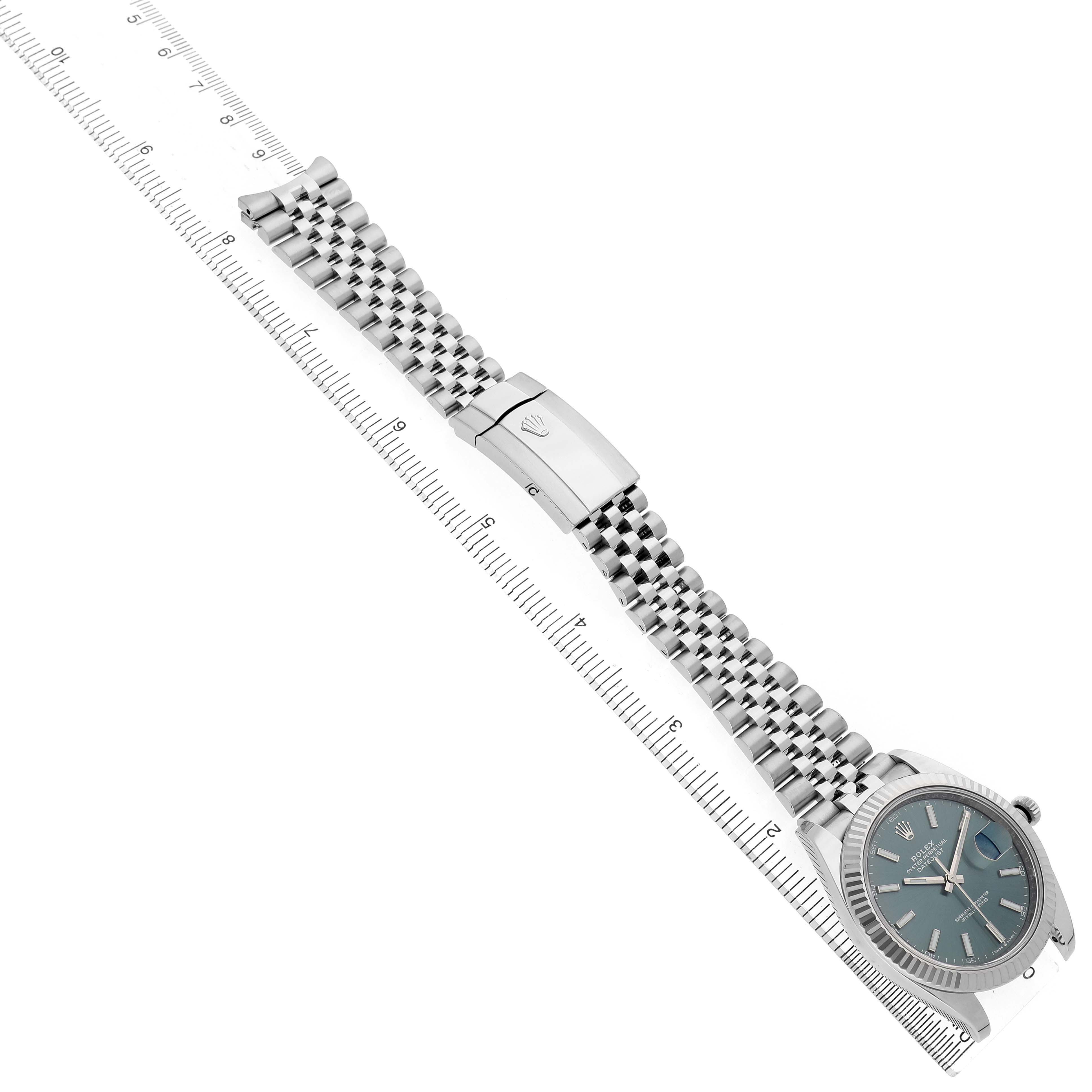 The image shows a Rolex Datejust 41 126334 Men's Stainless Steel Green Dial watch laid flat, displaying the face, Jubilee bracelet, and clasp alongside a ruler for scale.