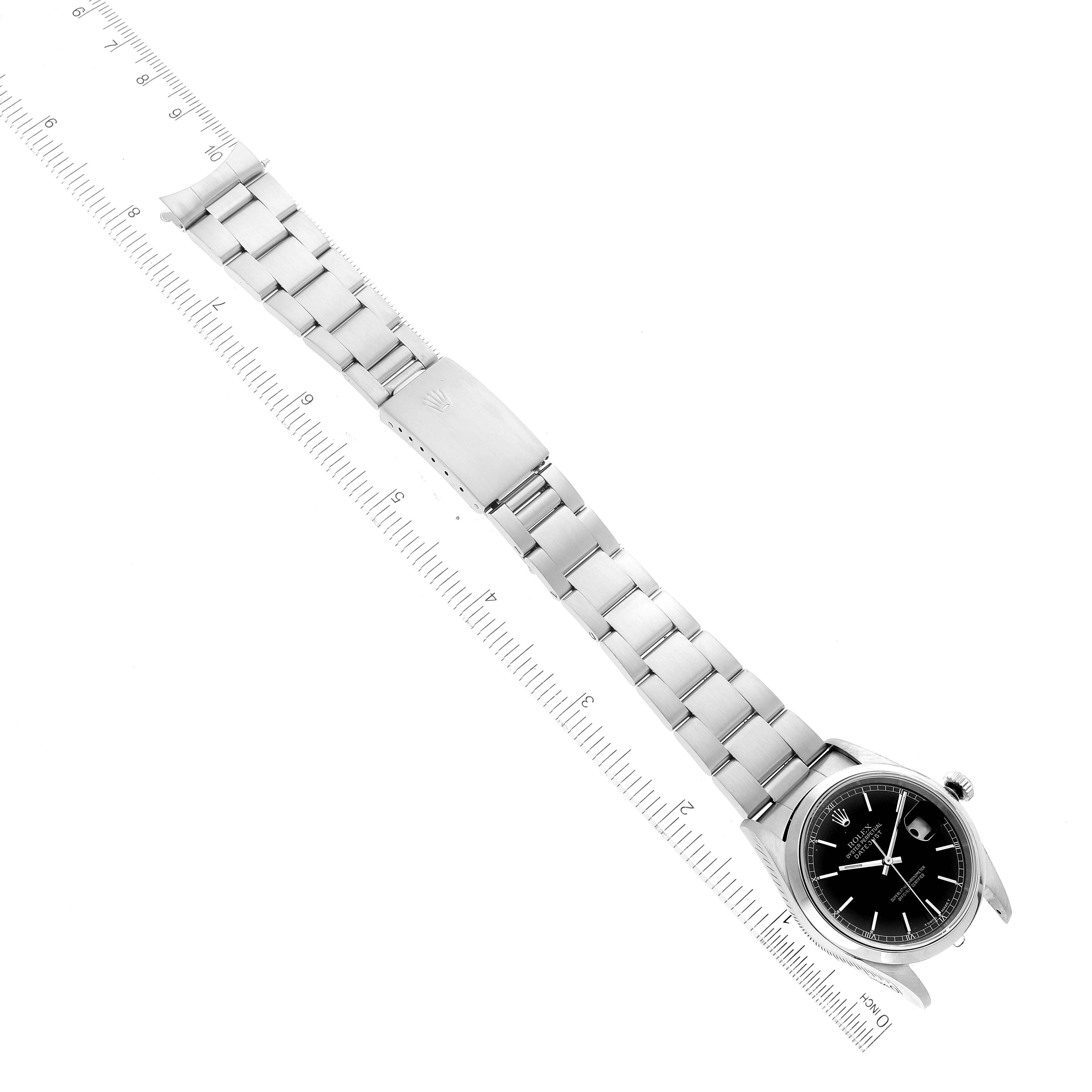 This image shows a top-down view of a Rolex Datejust 16200 Men's Stainless Steel Black Dial 16200 Men's Stainless Steel Black Dial watch, highlighting the face, bezel, and bracelet next to a ruler.