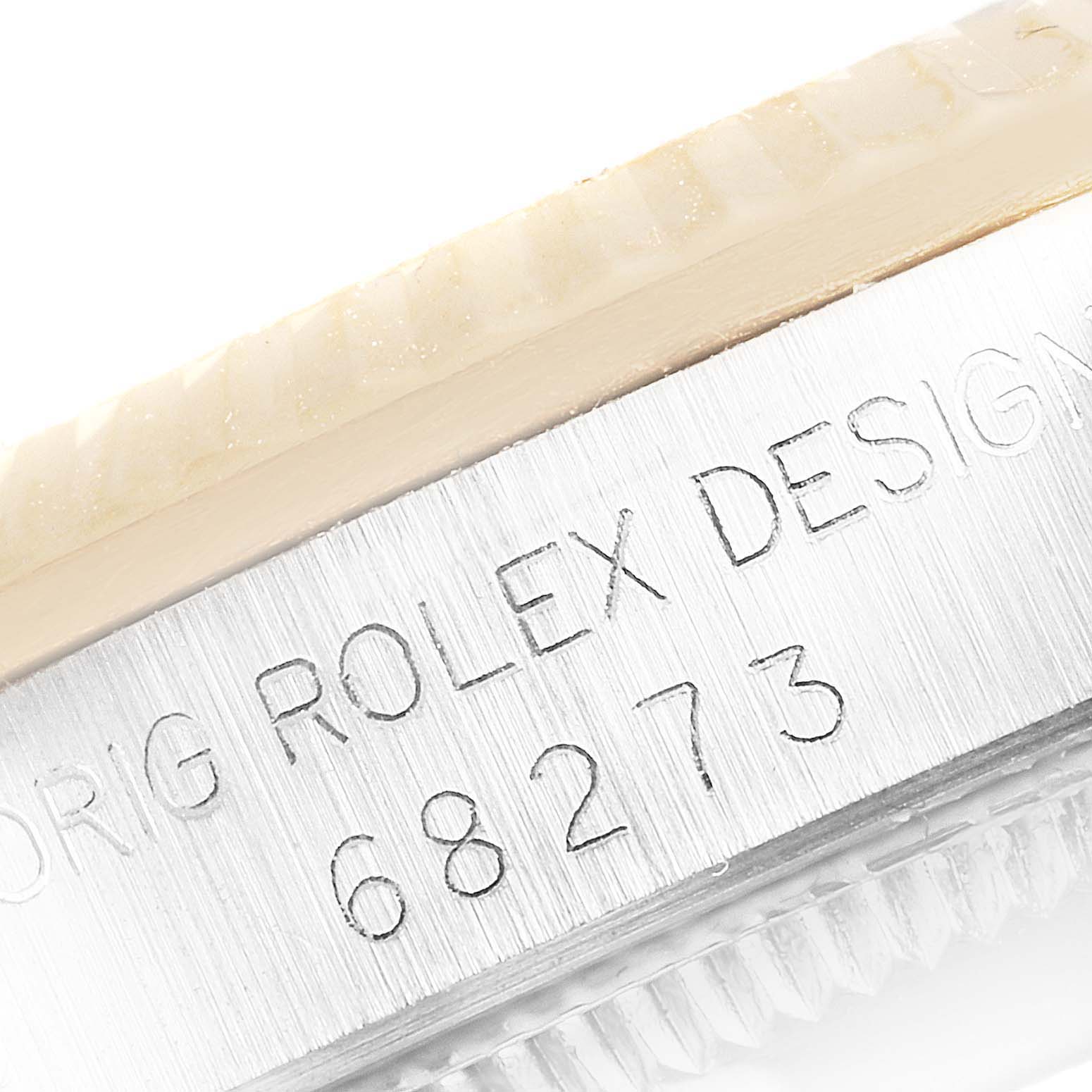 This image shows a close-up of the engraved serial number "68273" on the casing of a Mid-Size Rolex watch.
