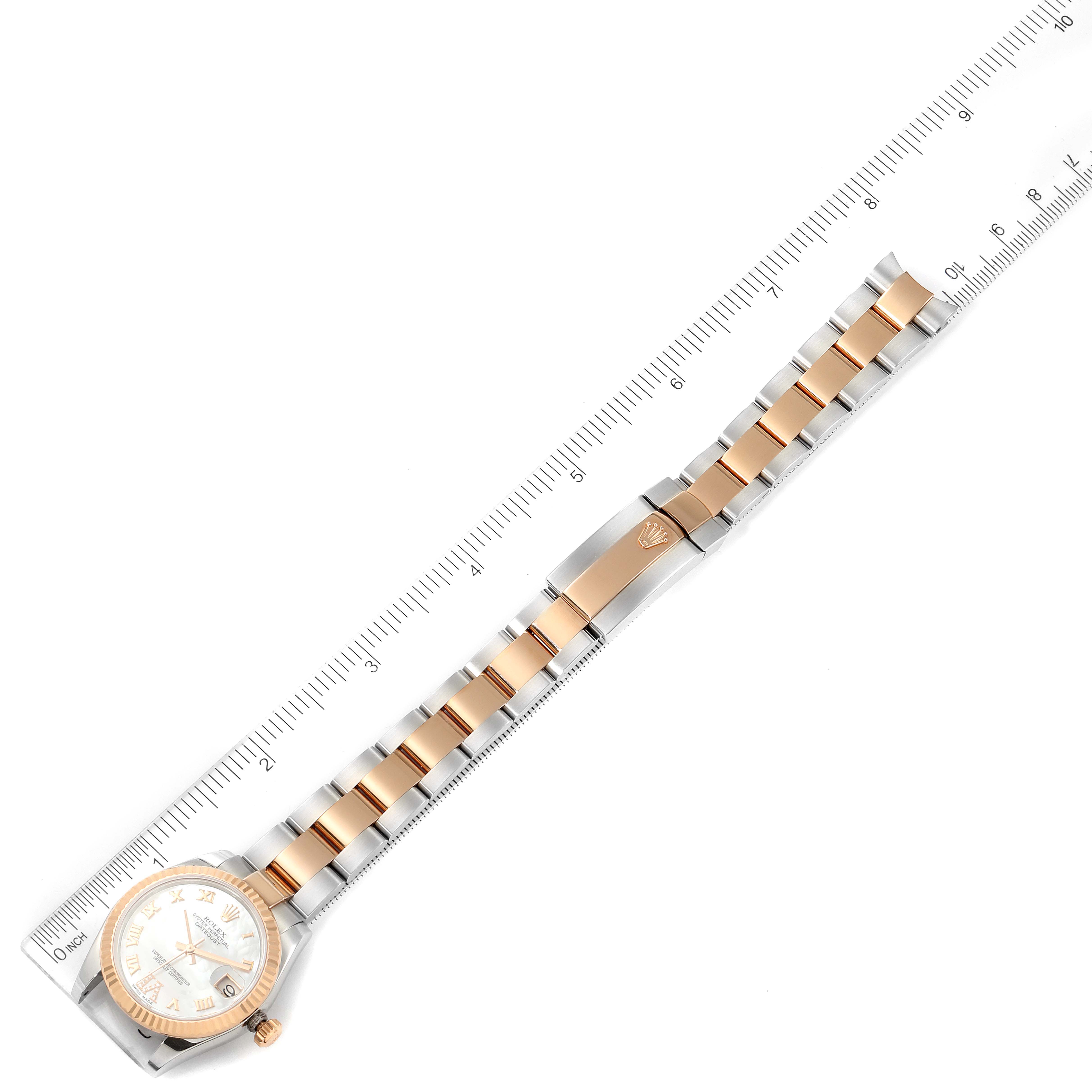 The image shows a full view of a Rolex Mid-Size 178271 Women's Steel and Gold (two tone) Mother of Pearl Dial 178271 Women's Steel and Gold (two tone) Mother of Pearl Dial model watch laid flat next to a ruler, highlighting the watch face, bezel, and the entire bracelet.