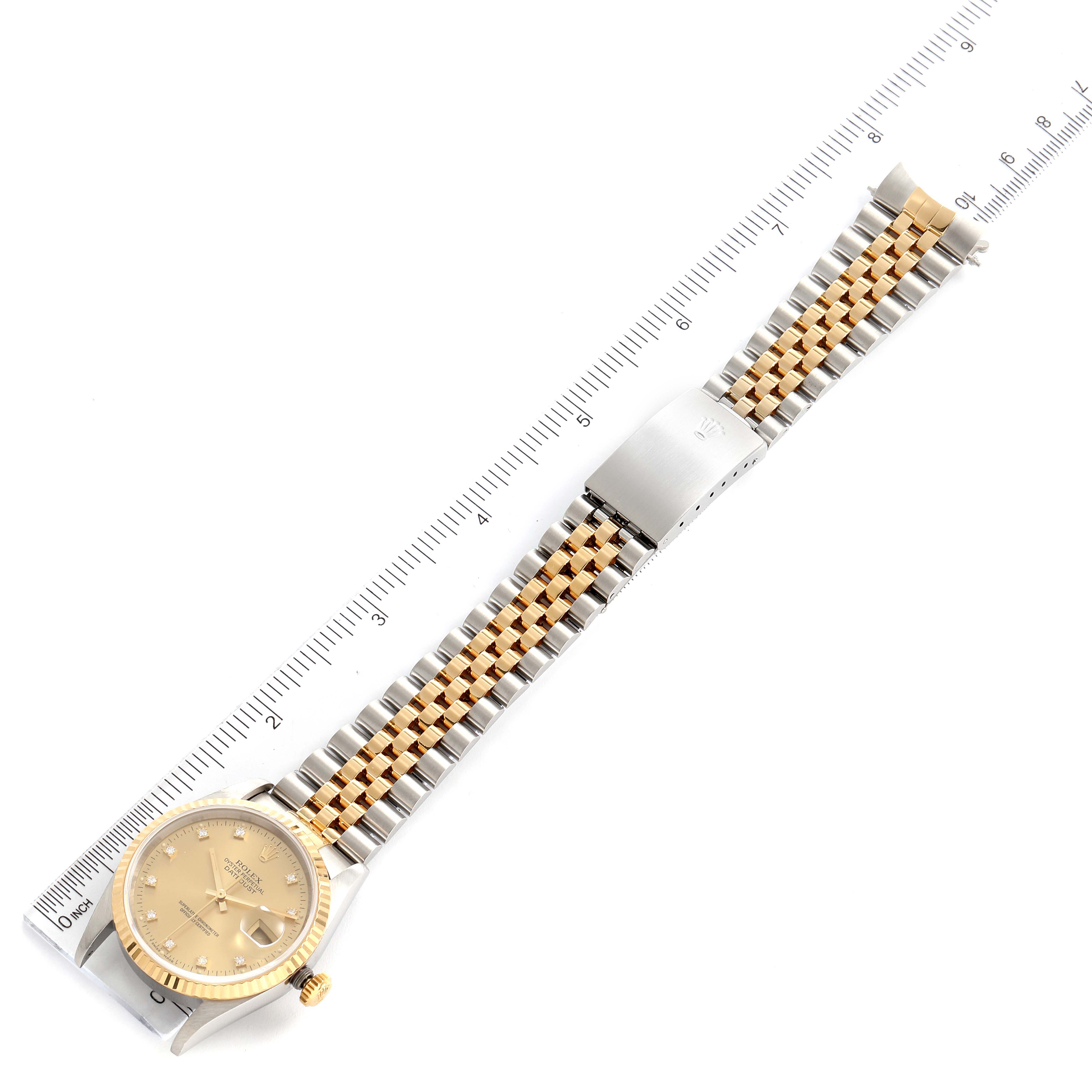 The image shows a top view of a Rolex Datejust 16233 Men's Steel and Gold (two tone) Champagne Dial 16233 Men's Steel and Gold (two tone) Champagne Dial watch with a two-tone bracelet laid alongside a ruler.
