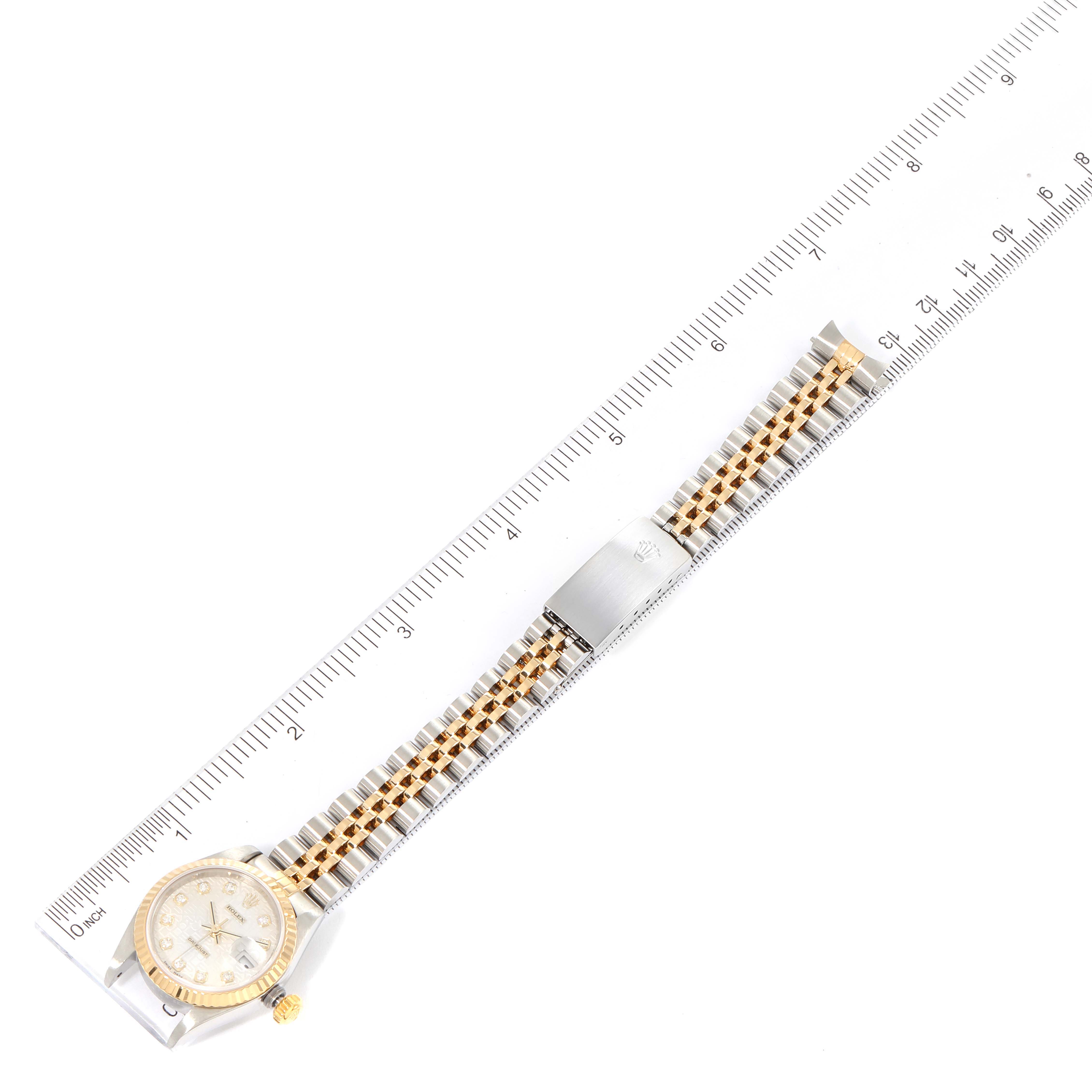 The Rolex Datejust 79173 Women's Steel and Gold (two tone) Silver Dial 79173 Women's Steel and Gold (two tone) Silver Dial watch is shown laid flat with a ruler beside it, displaying the entire band and face from an overhead angle.