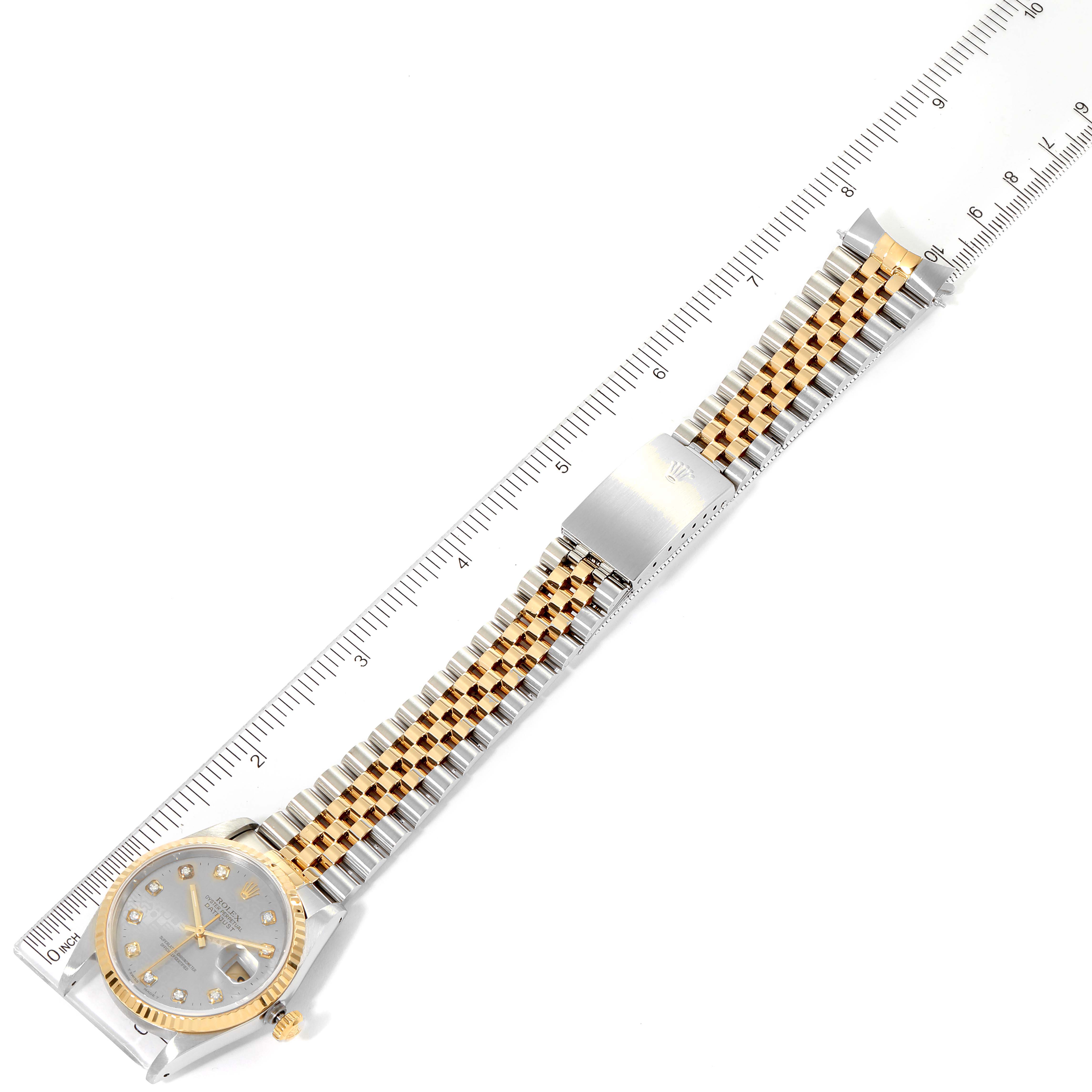 The Rolex Datejust 16233 Men
s Steel and Gold (two tone) Grey Dial 16233 Men
s Steel and Gold (two tone) Grey Dial watch is shown fully extended, positioned horizontally next to a ruler for measurement.