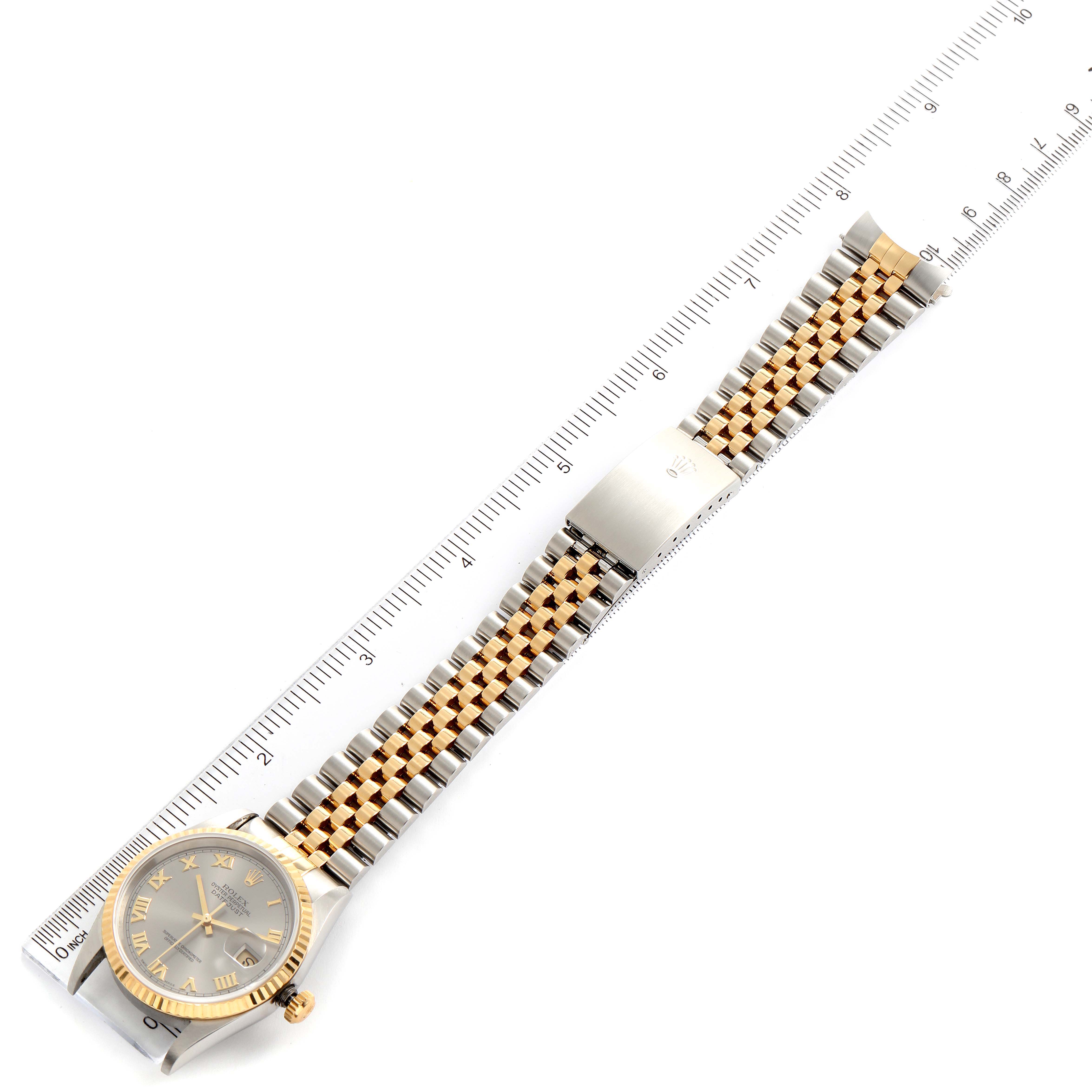 The image shows a top-down view of a Rolex Datejust 16233 Men
s Steel and Gold (two tone) Grey Dial 16233 Men
s Steel and Gold (two tone) Grey Dial watch with its band fully extended next to a ruler.