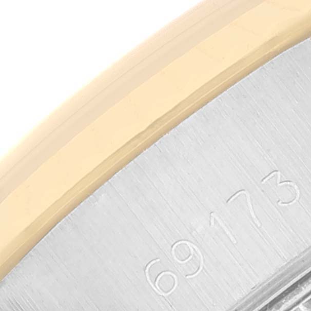 The image shows a close-up of the side engraving and edge of the bezel of a Rolex Datejust 69173 Women
s Steel and Gold (two tone) White Dial 69173 Women
s Steel and Gold (two tone) White Dial watch.