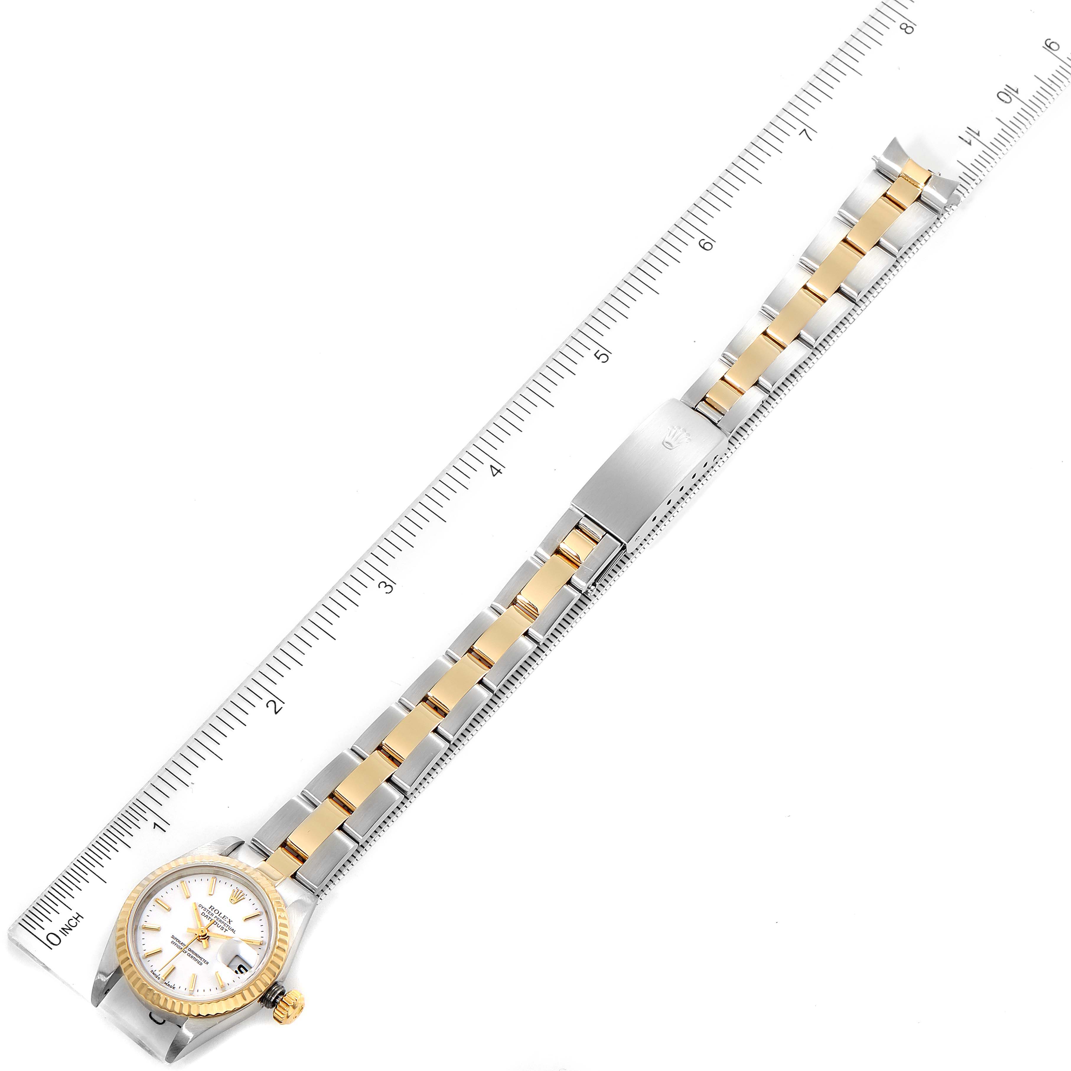 The image shows a top-down view of a Rolex Datejust 79173 Women's Steel and Gold (two tone) White Dial 79173 Women's Steel and Gold (two tone) White Dial watch with its bracelet extended alongside a ruler for measurement.