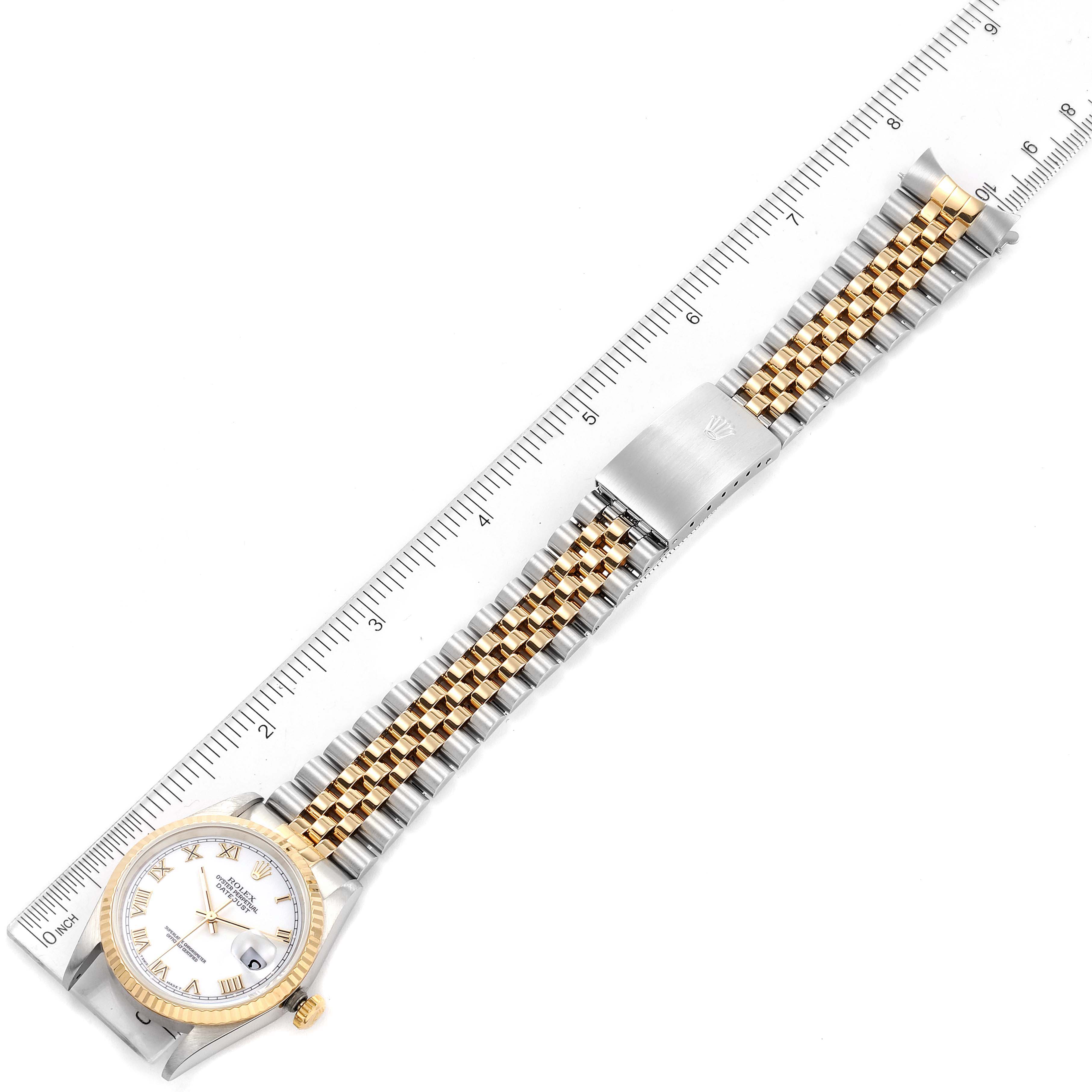 The Rolex Datejust 16233 Men's Steel and Gold (two tone) White Dial 16233 Men's Steel and Gold (two tone) White Dial watch is shown from a top-down angle, displaying the full band alongside a measuring ruler.