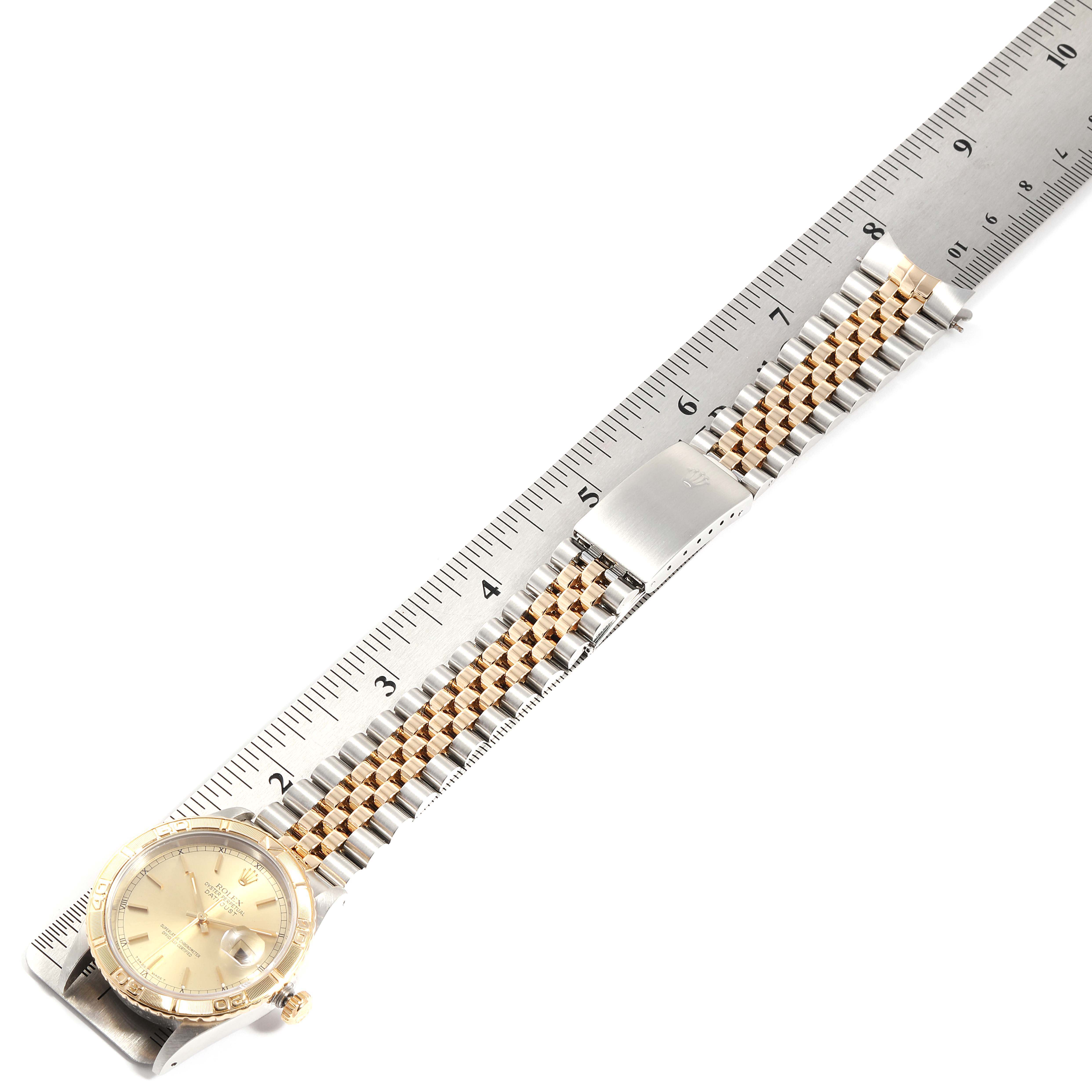 This image shows a Rolex Turn-o-Graph 16263 Men
s Steel and Gold (two tone) Champagne Dial 16263 Men
s Steel and Gold (two tone) Champagne Dial watch laid flat with a ruler next to it, highlighting the bracelet and face.