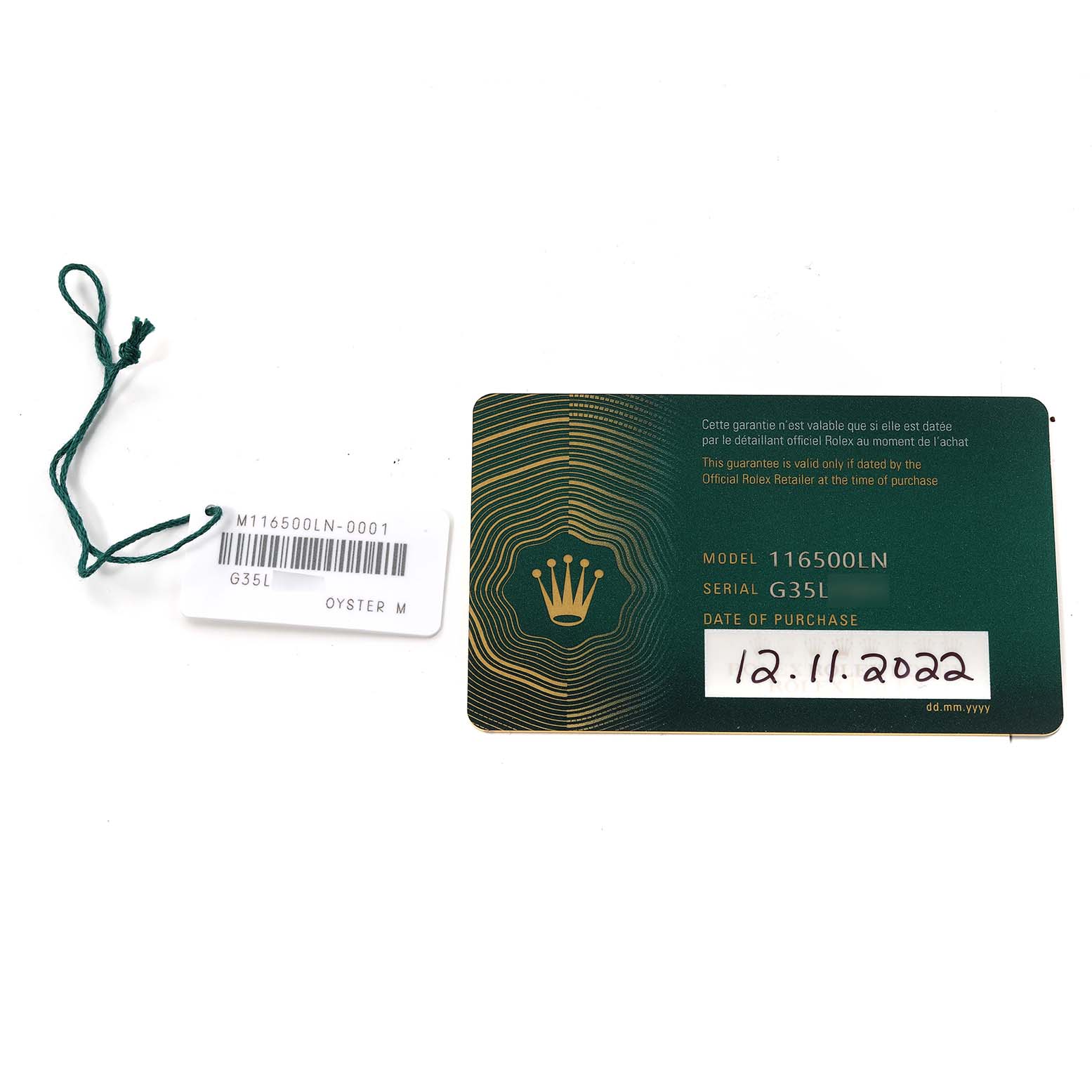 The image shows the Rolex Daytona 116500 Men's Stainless Steel White Dial 116500 Men's Stainless Steel White Dial model (116500LN) warranty card and a green tag with the model and serial number.