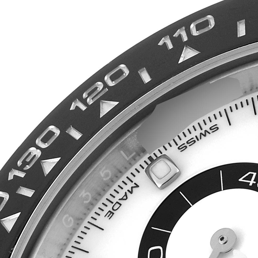 The image shows a close-up of the bezel and part of the dial of a Rolex Daytona 116500 Men's Stainless Steel White Dial 116500 Men's Stainless Steel White Dial watch.