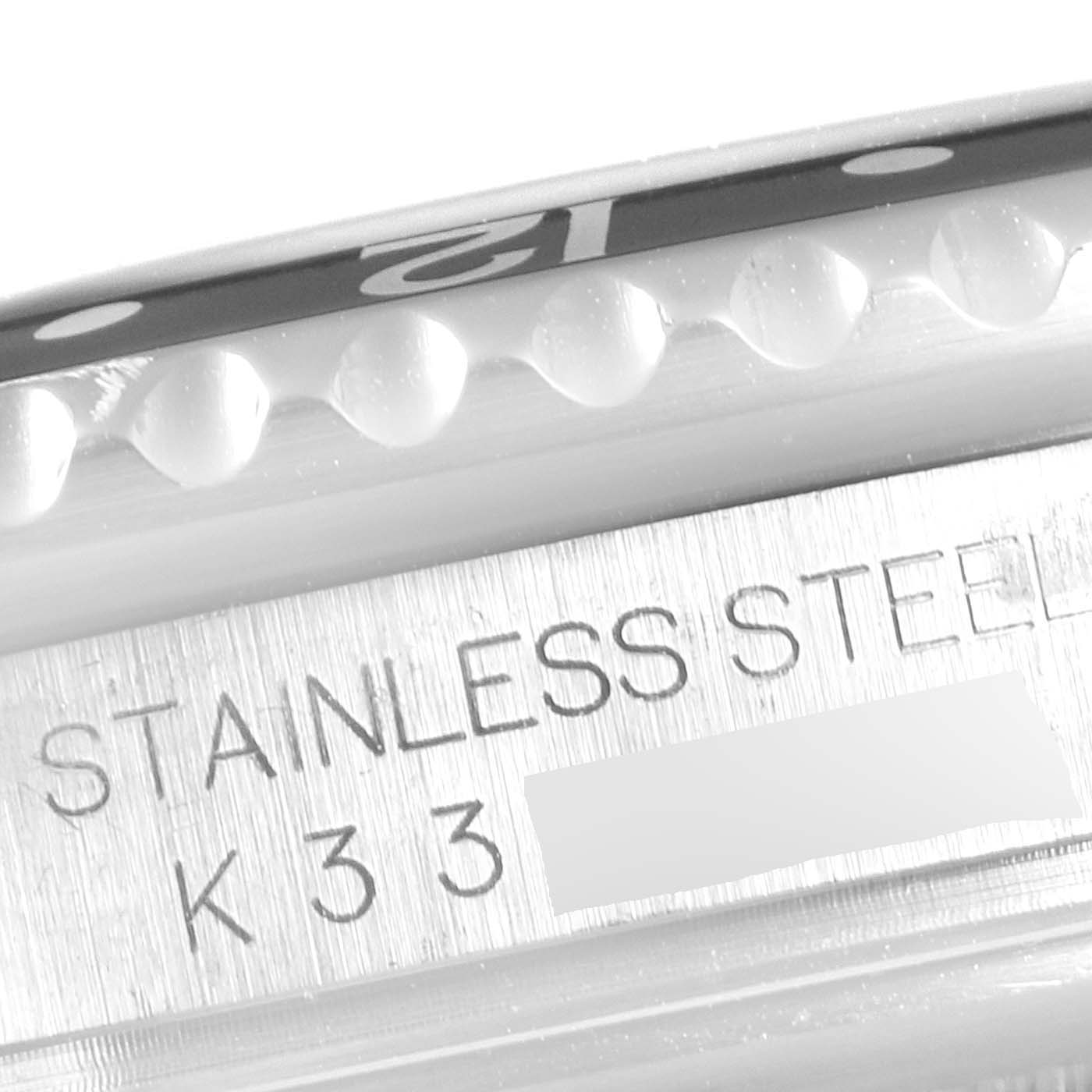 The image shows a close-up of the Rolex GMT-Master 16710 Men's Stainless Steel Black Dial 16710 Men's Stainless Steel Black Dial watch’s stainless steel bezel and case with engraved markings.