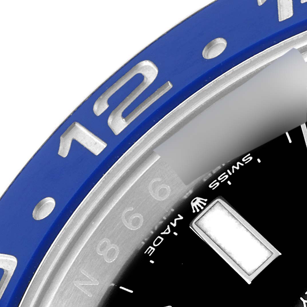 The image shows a close-up of the bezel and part of the dial of a Rolex GMT-Master 126710 Men
s Stainless Steel Black Dial 126710 Men
s Stainless Steel Black Dial watch, highlighting the 12-hour marker and Swiss-Made text.