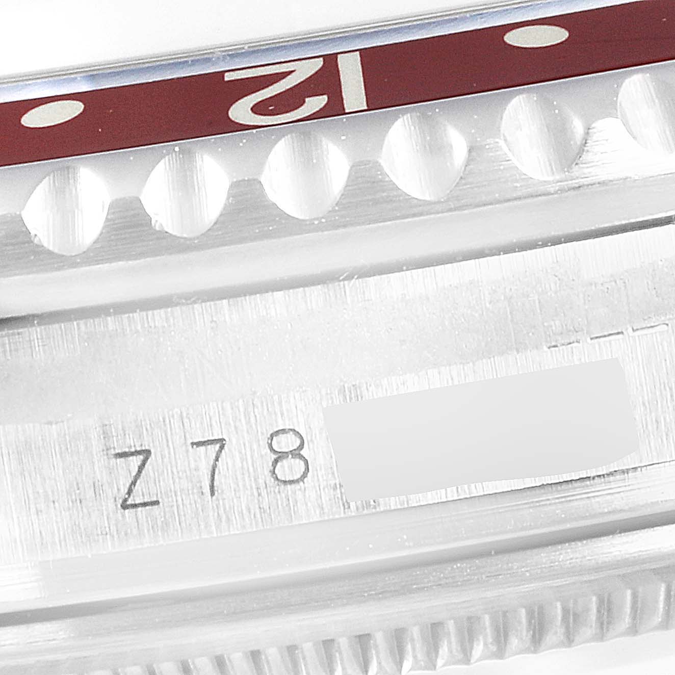 The image shows a close-up of the Rolex GMT-Master 16710 Men's Stainless Steel Black Dial 16710 Men's Stainless Steel Black Dial's bezel and part of the case with a visible serial number.