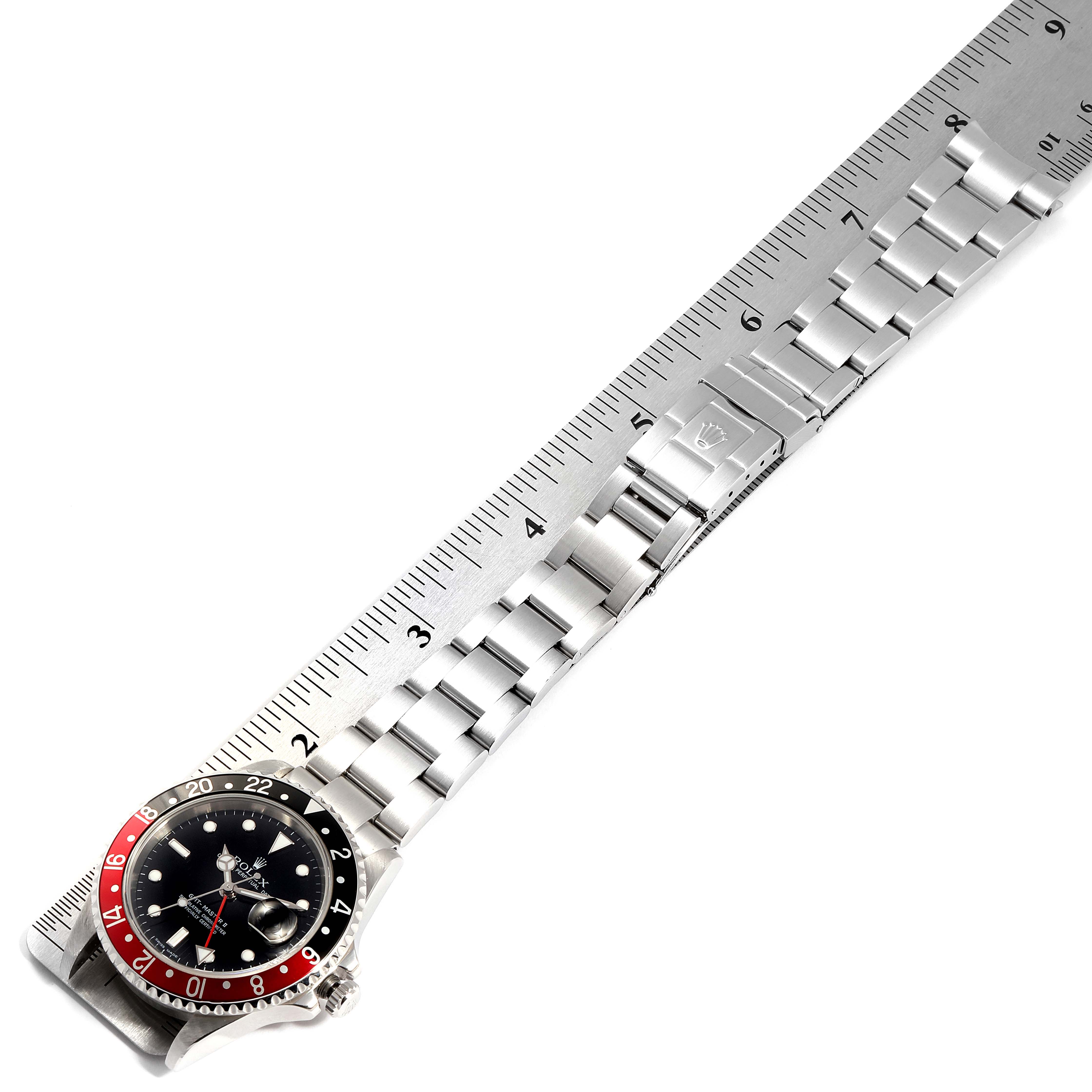 This image shows a top view of the Rolex GMT-Master 16710 Men's Stainless Steel Black Dial 16710 Men's Stainless Steel Black Dial watch, focusing on the bezel, dial, and bracelet next to a ruler.