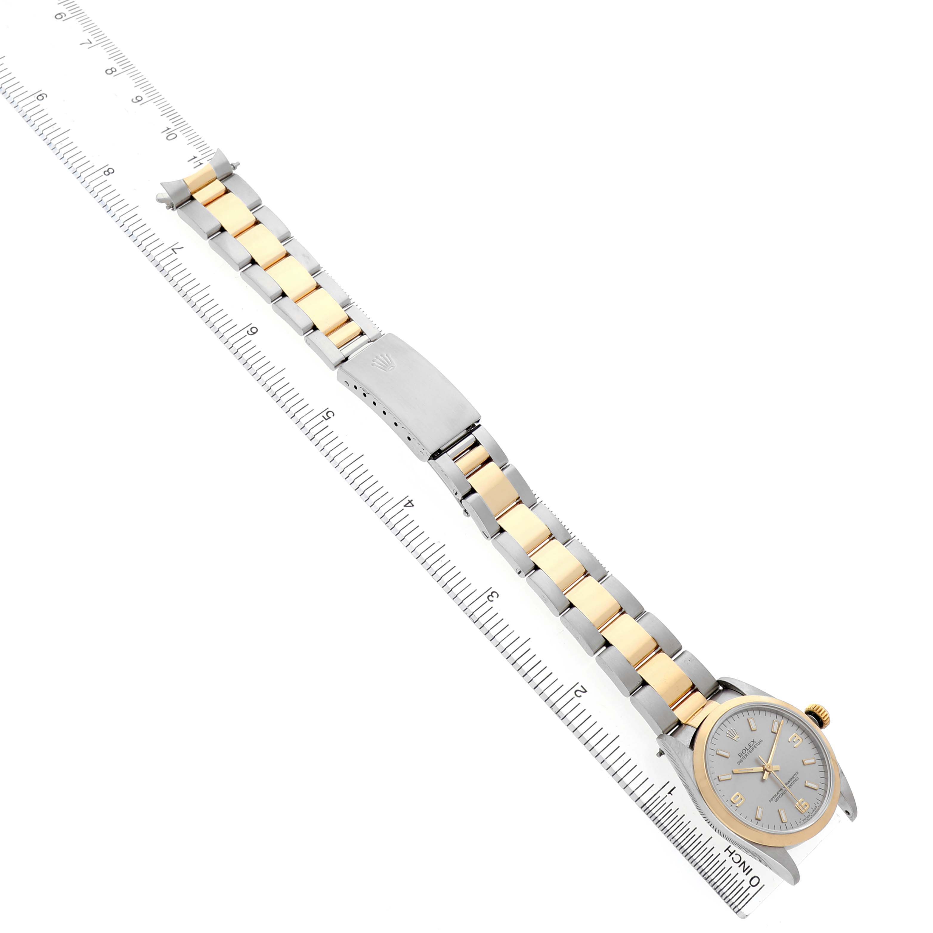 The Rolex Oyster Perpetual 67483 Women's Steel and Gold (two tone) Grey Dial watch is shown from an angled top view, displaying its full bracelet and clasp.