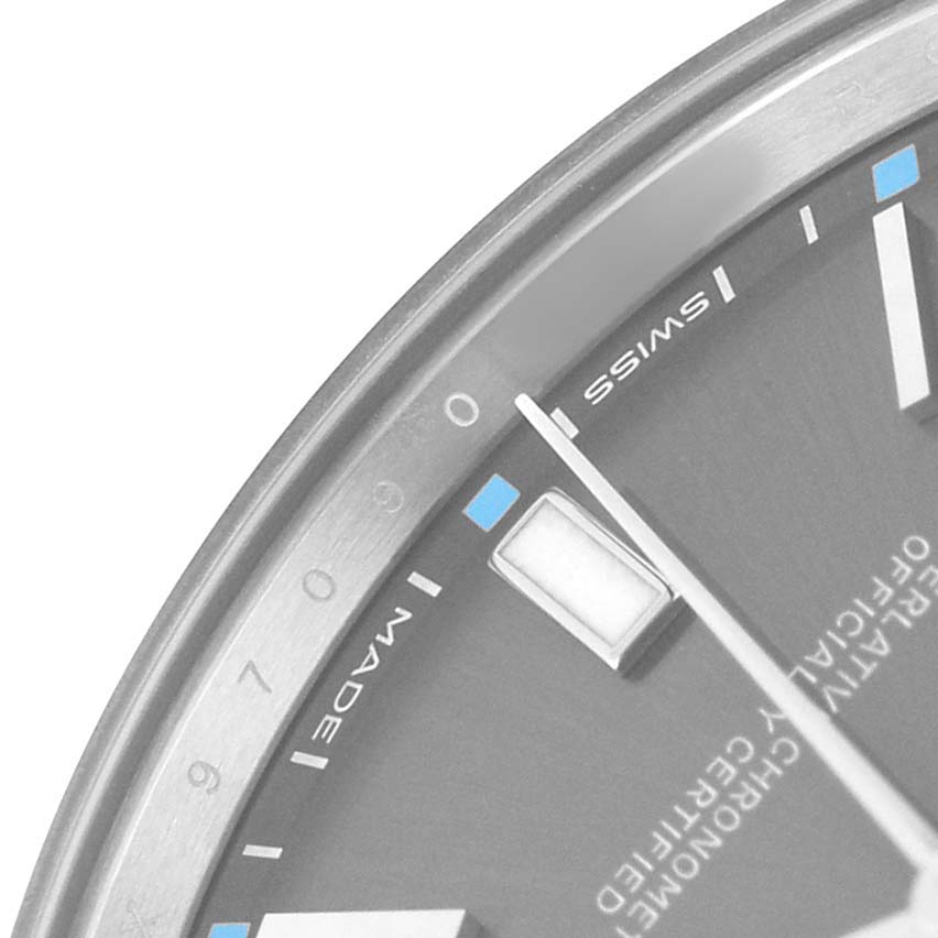 The image shows a close-up of the dial edge, indices, and part of the bezel of a Rolex Oyster Perpetual 114300 Men's Stainless Steel Grey Dial watch.