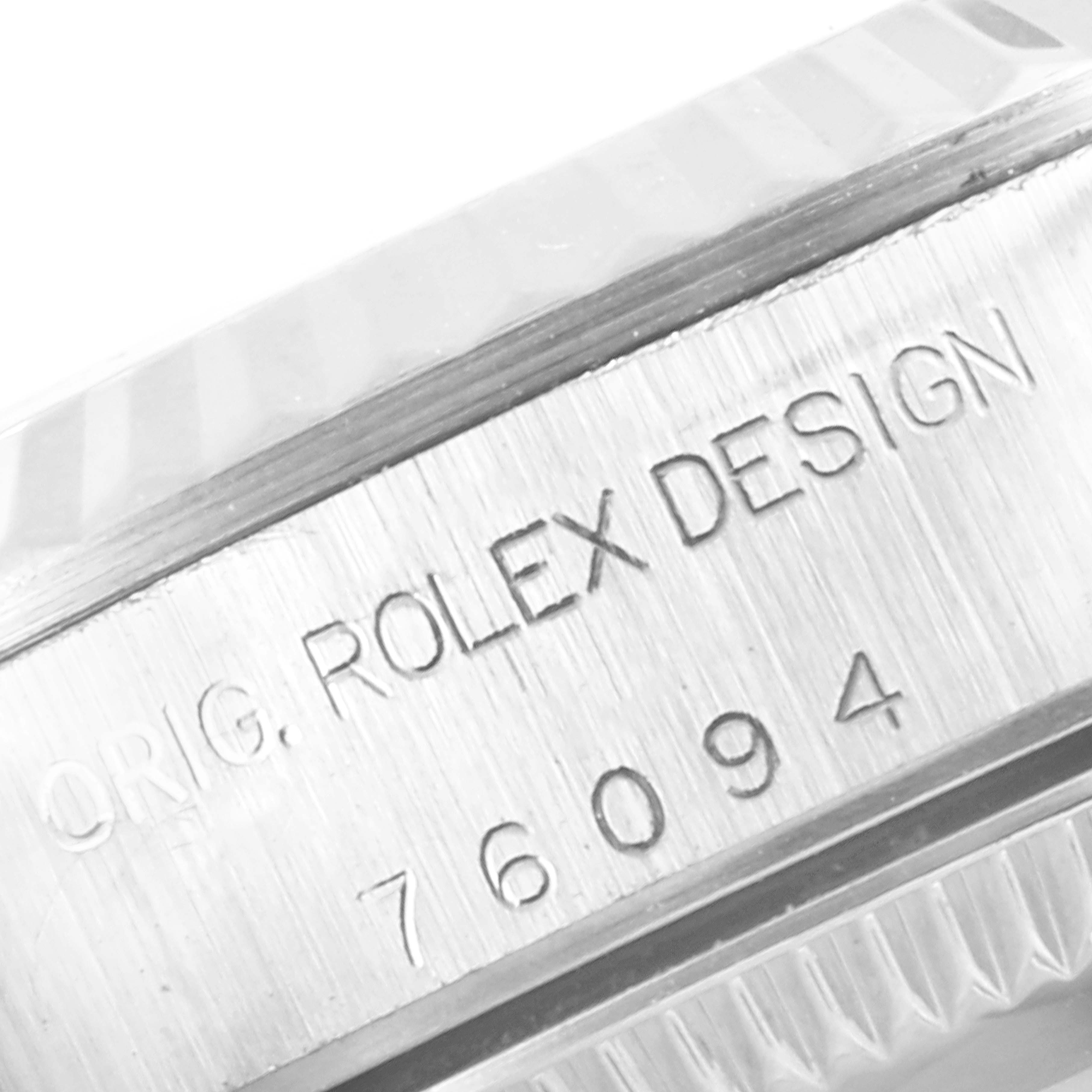 The image shows a close-up of the side of the case of a Rolex Oyster Perpetual 76094 Women's Stainless Steel Black Dial 76094 Women's Stainless Steel Black Dial watch, displaying the Rolex design inscriptions and model number.