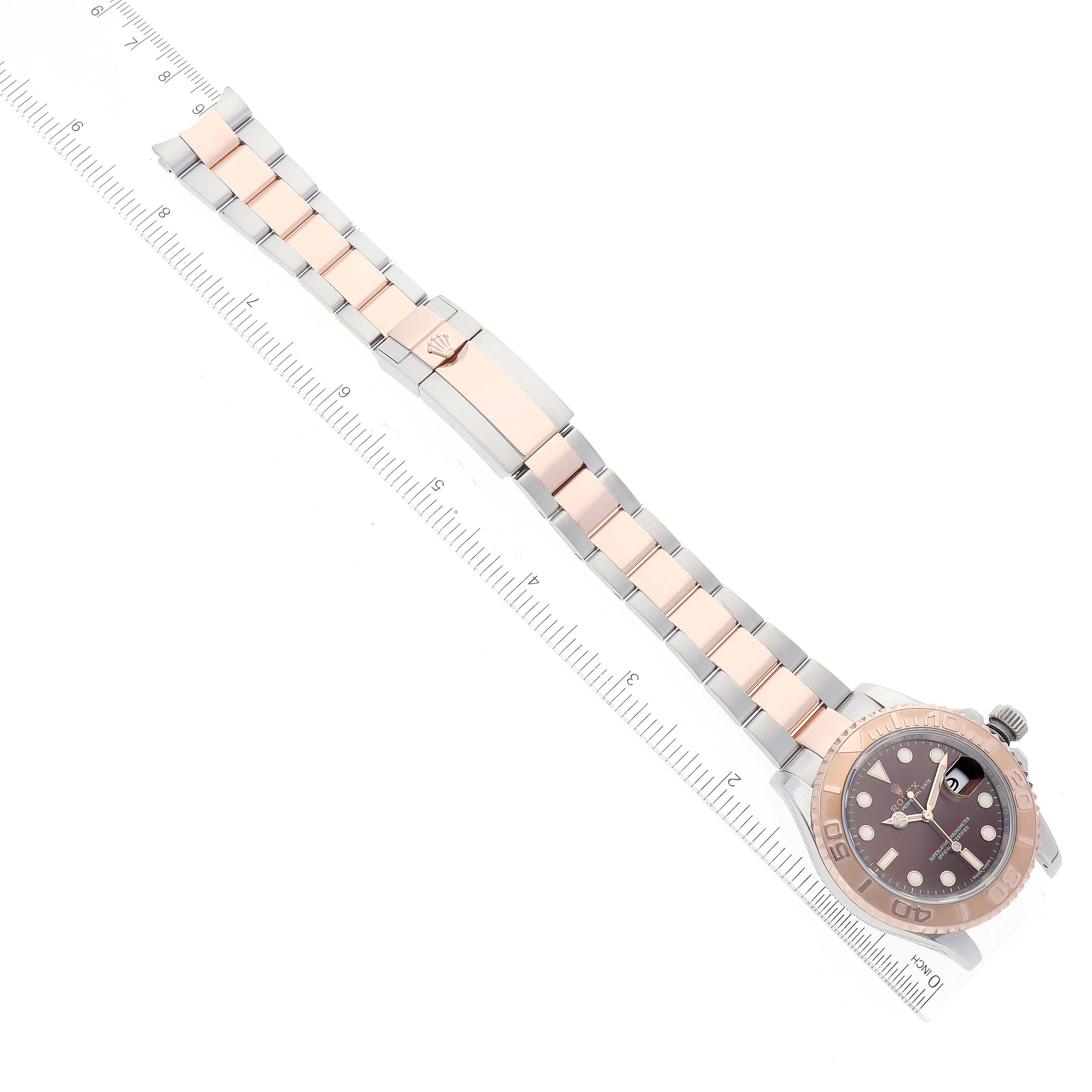 The image shows a Rolex Yacht-Master 116621 Men's Steel and Gold (two tone) Brown Dial 116621 Men's Steel and Gold (two tone) Brown Dial watch laid flat, displaying the face, bezel, bracelet, and clasp beside a measuring ruler.