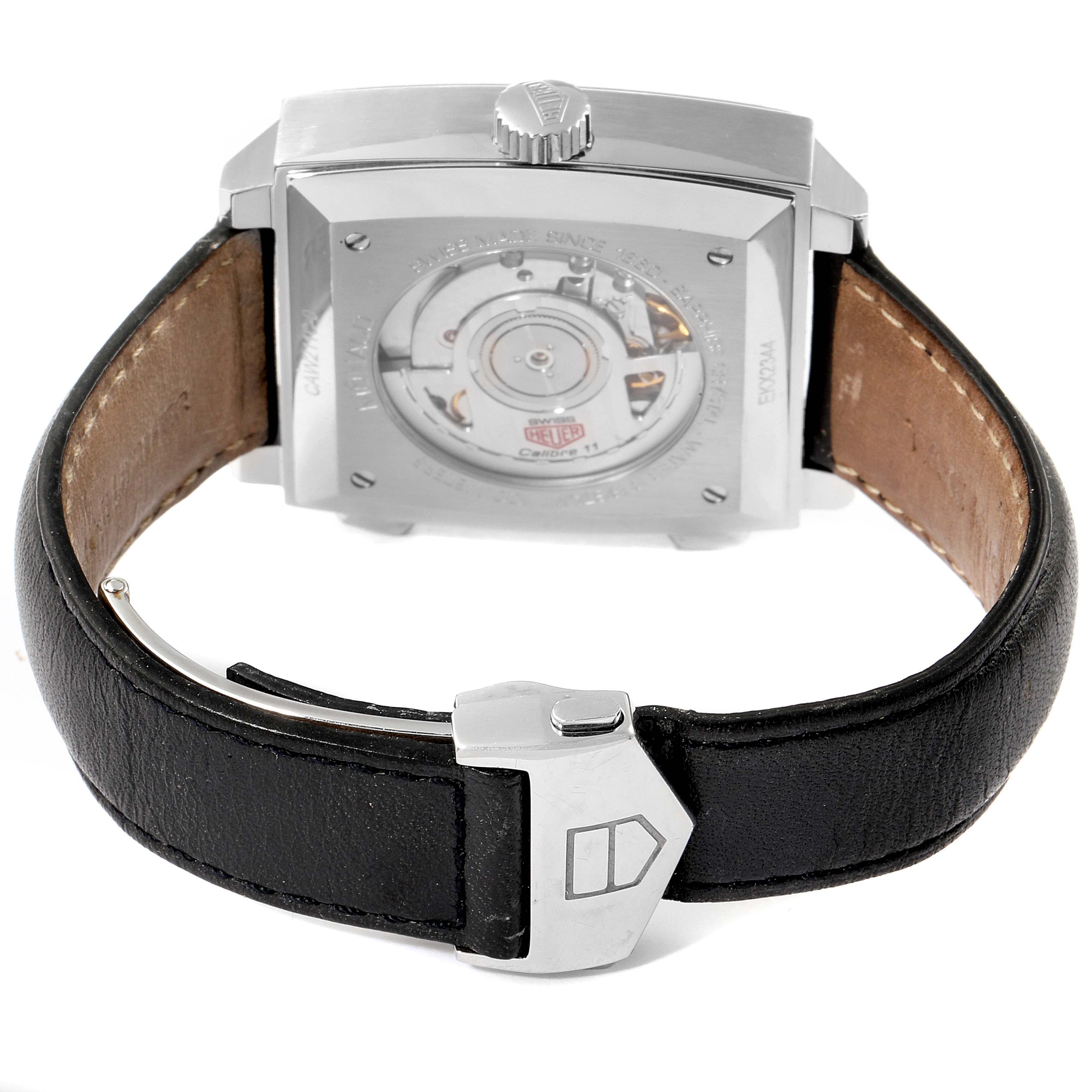 The image shows the back and clasp of a Tag Heuer Monaco watch, revealing its automatic movement and leather strap.