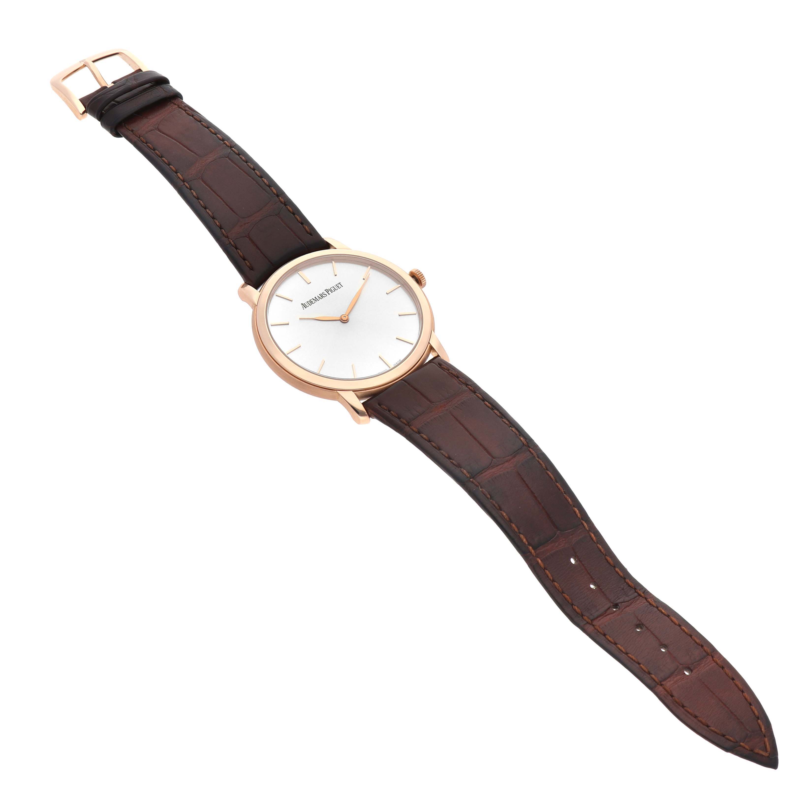 The Audemars Piguet Jules 15180R Men's Rose Gold Silver Dial watch is shown at an oblique angle featuring its face, brown leather strap, and gold casing.