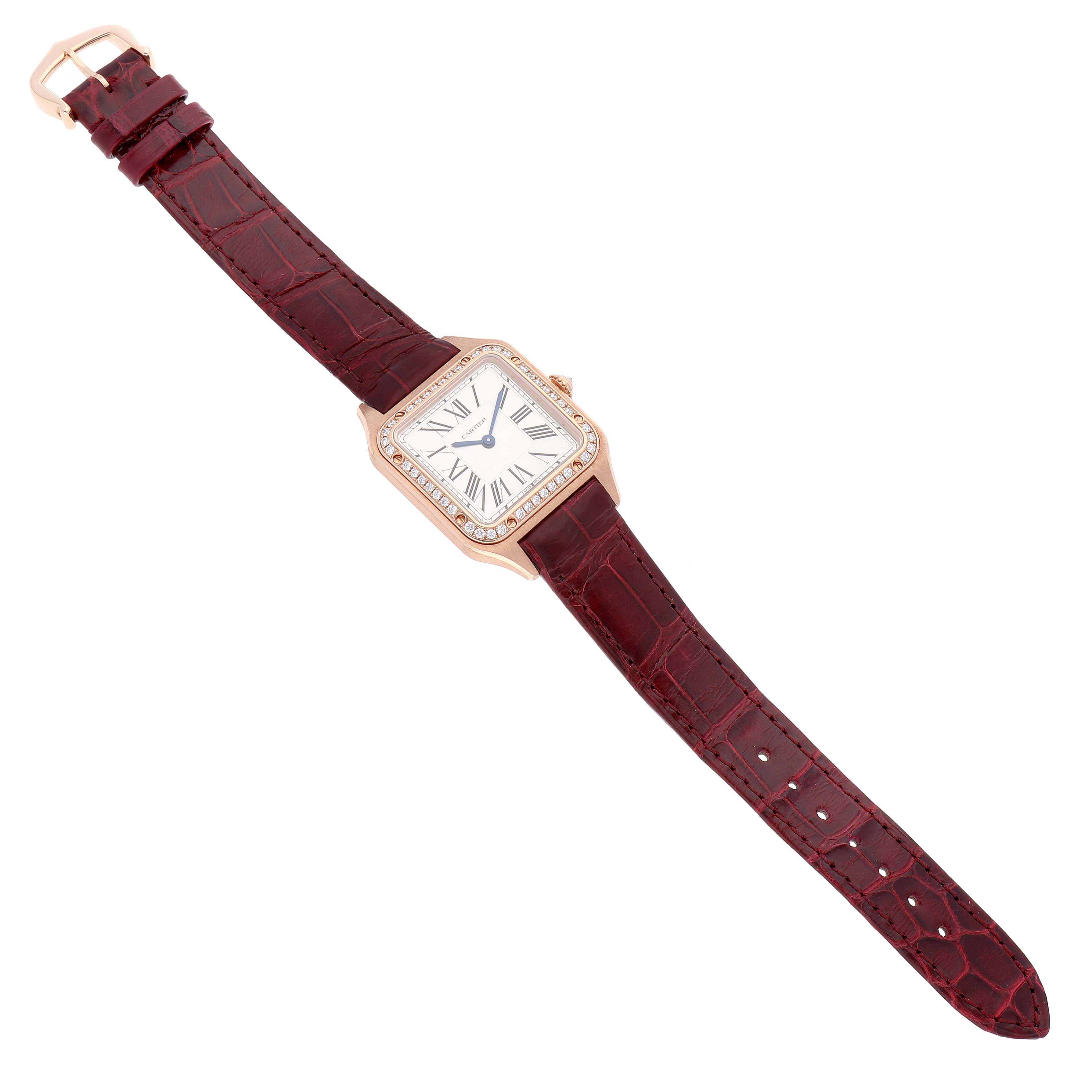 The Cartier Santos WJSA0017 Women
s Rose Gold Silver Dial WJSA0017 Women
s Rose Gold Silver Dial Dumont watch is shown from a top-down angle, displaying the face, bezel, and red strap.