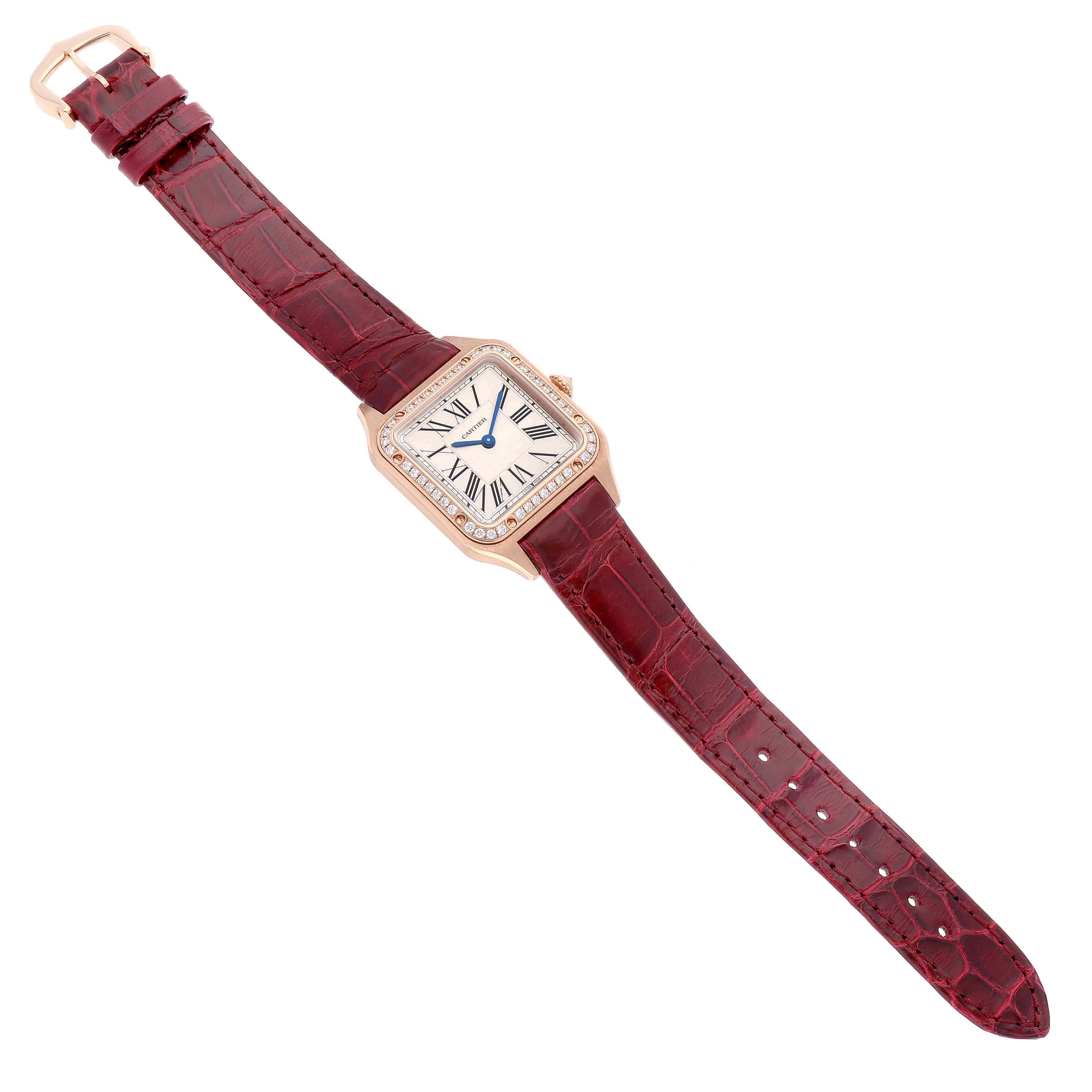 The Cartier Santos WJSA0017 Women's Rose Gold Silver Dial watch is shown from a top-down angle, displaying its square face and red leather strap.