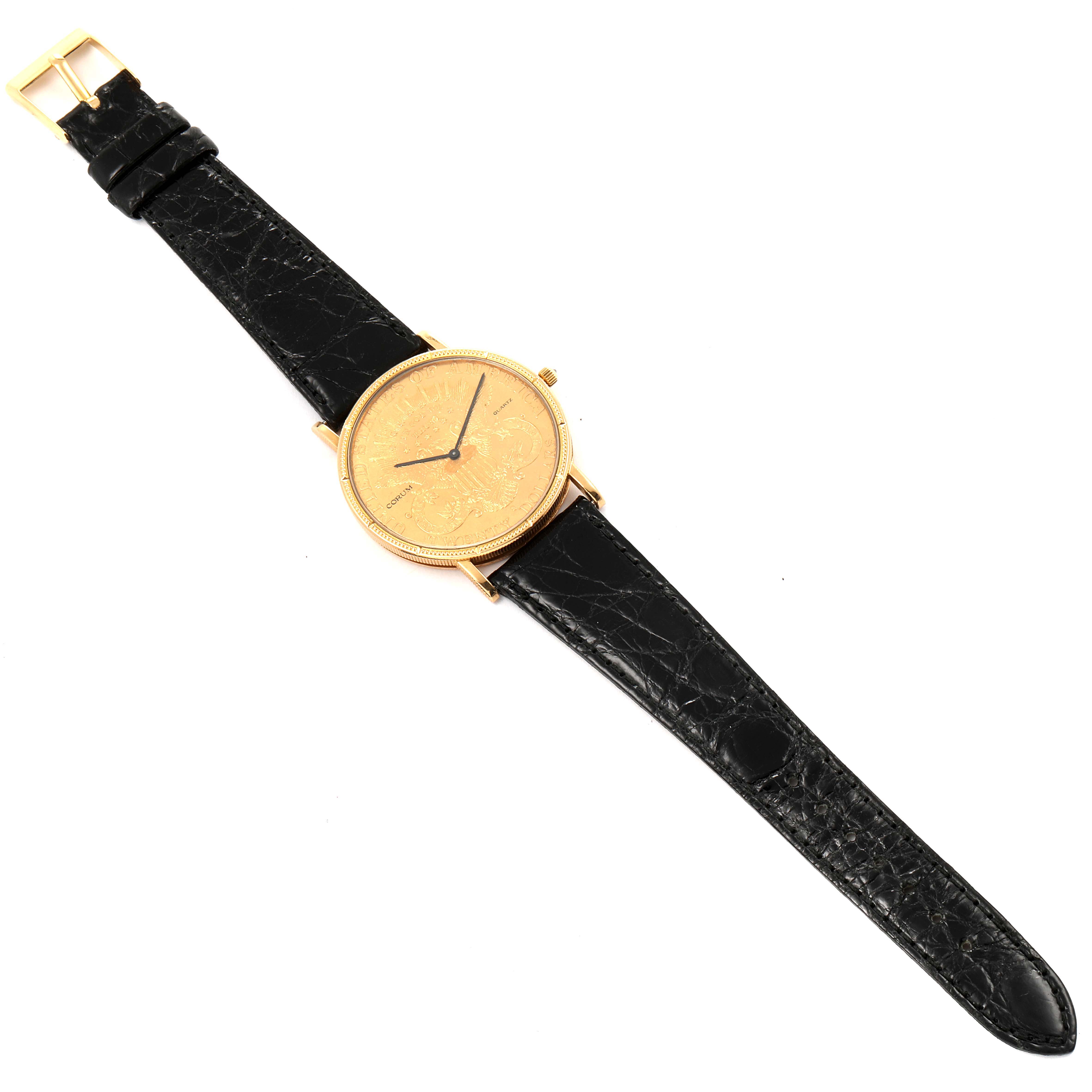 The Coin Watch model by Corum is shown at an overhead angle, displaying the gold case and black leather strap.