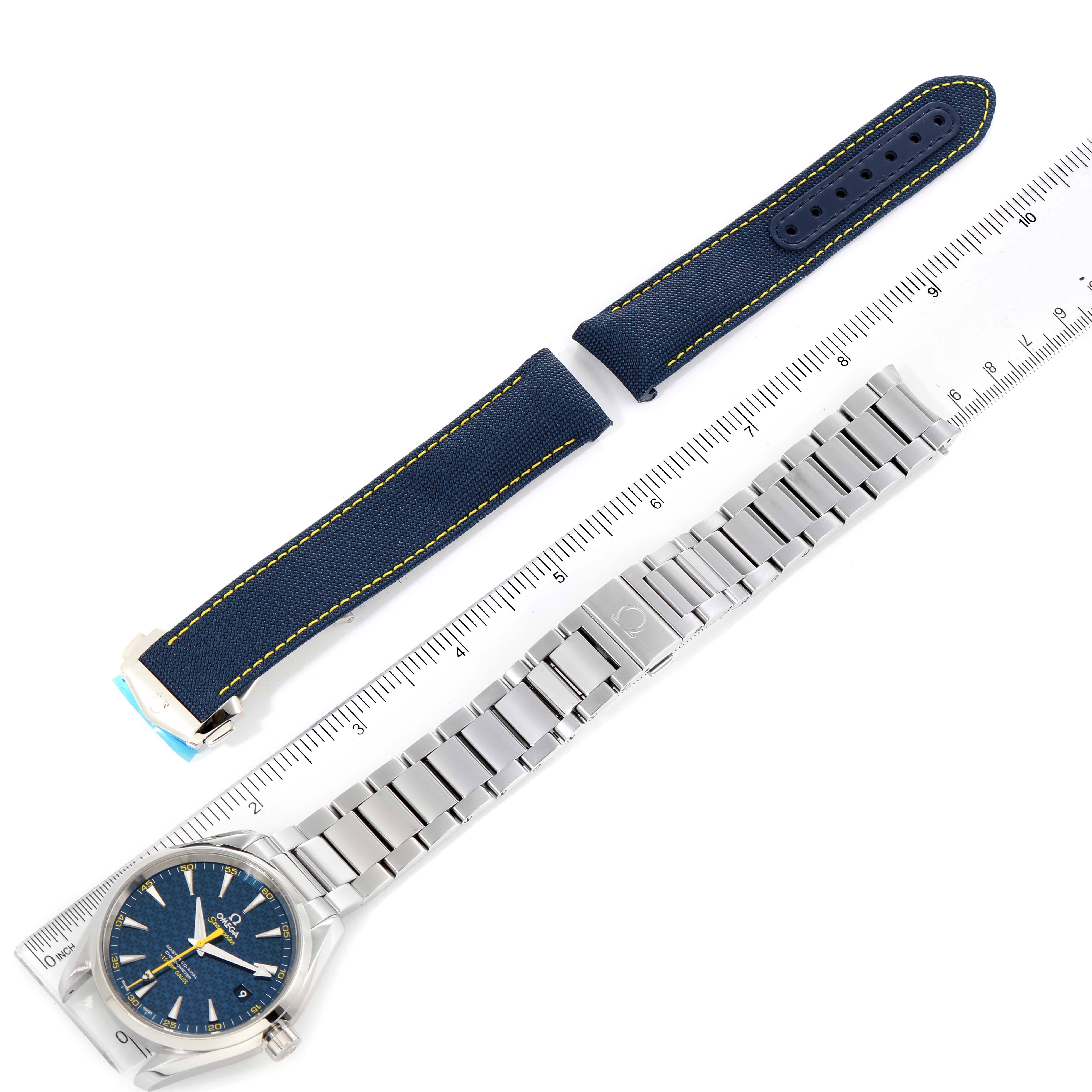 The image shows an Omega Aqua Terra 231.10.42.21.03.004 Men's Stainless Steel Blue Dial 231.10.42.21.03.004 Men's Stainless Steel Blue Dial watch with its metal bracelet and alternative fabric strap, placed parallel to a ruler.