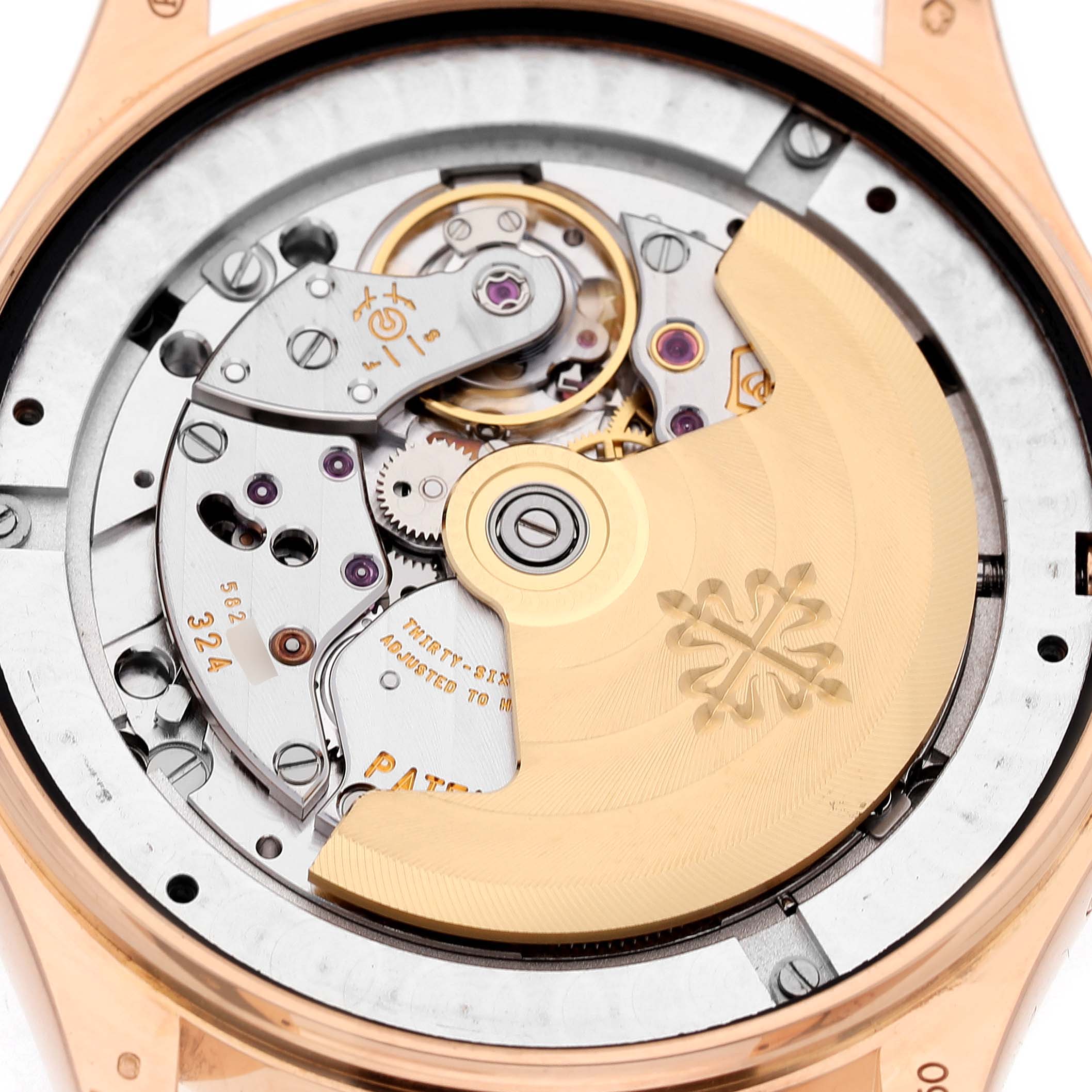 The image shows the intricate movement of a Patek Philippe Complications 5146R-001 Men's Rose Gold White Dial watch from the backside angle, highlighting gears and the rotor.